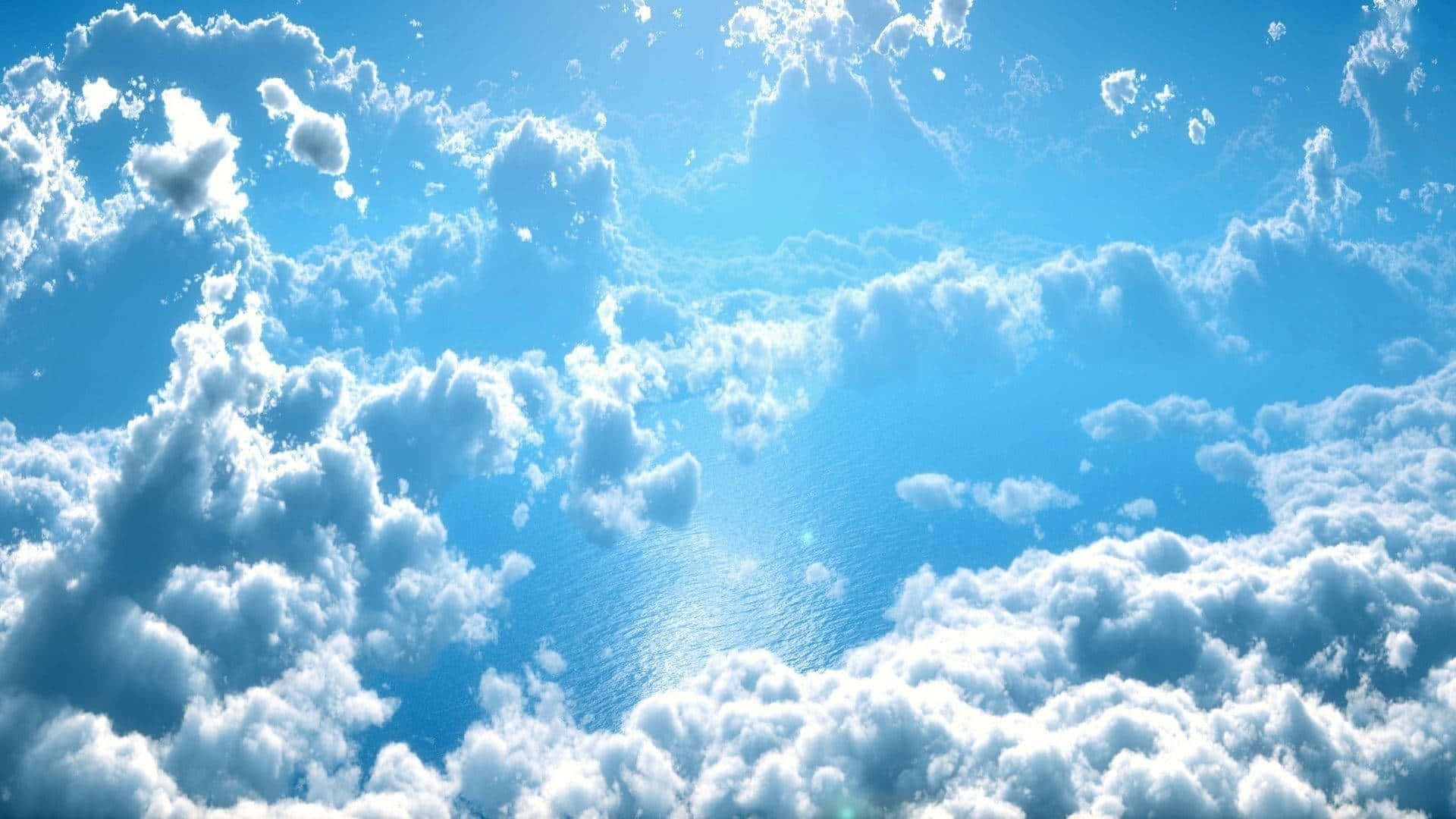 雲朵 桌布 壁紙 — 廣闊的藍天充滿了蓬鬆的白雲，沐浴在明亮的陽光下，營造出寧靜而寬廣的氛圍。