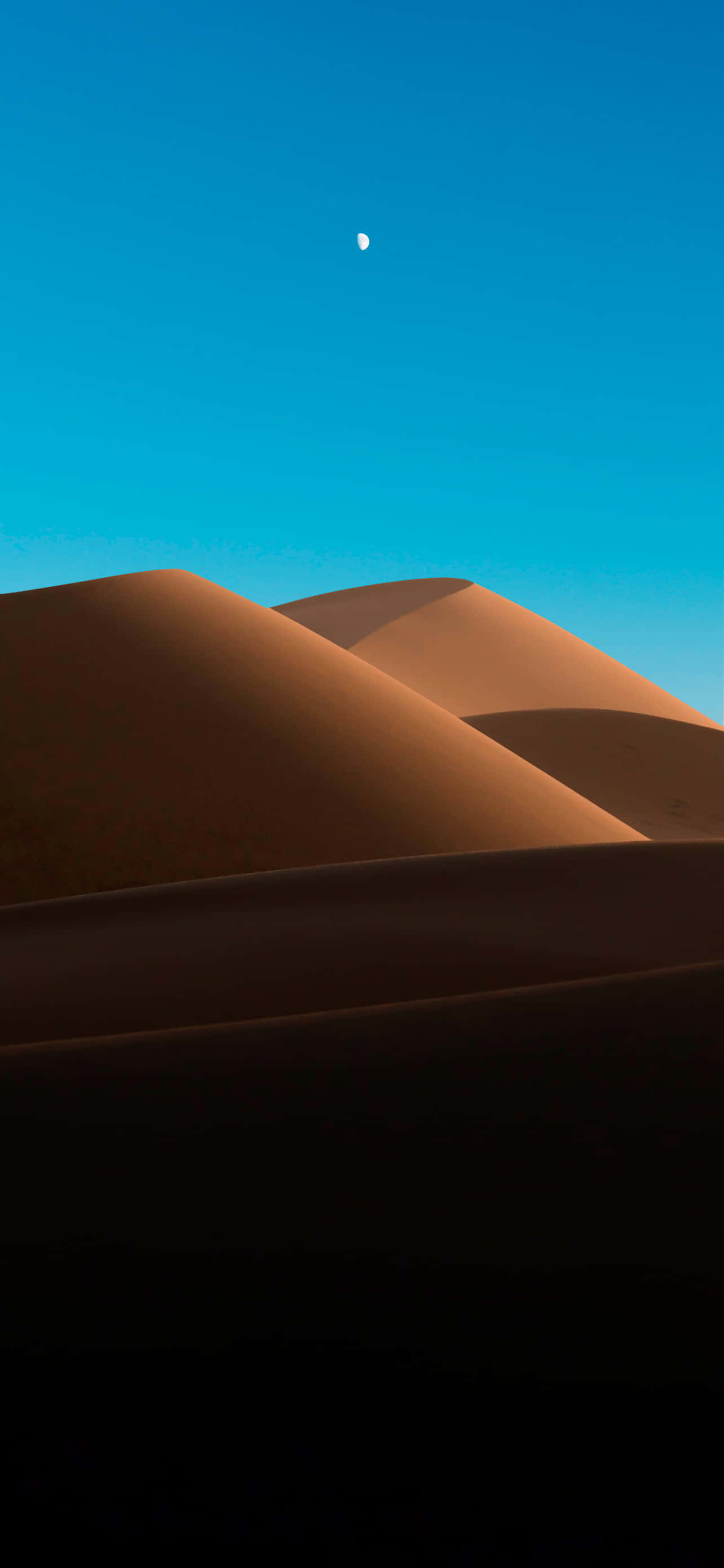 Desert iPhone 桌布 壁紙 — 廣闊的金色沙丘在清澈的藍天下延伸，上方有一彎小小的新月閃耀。