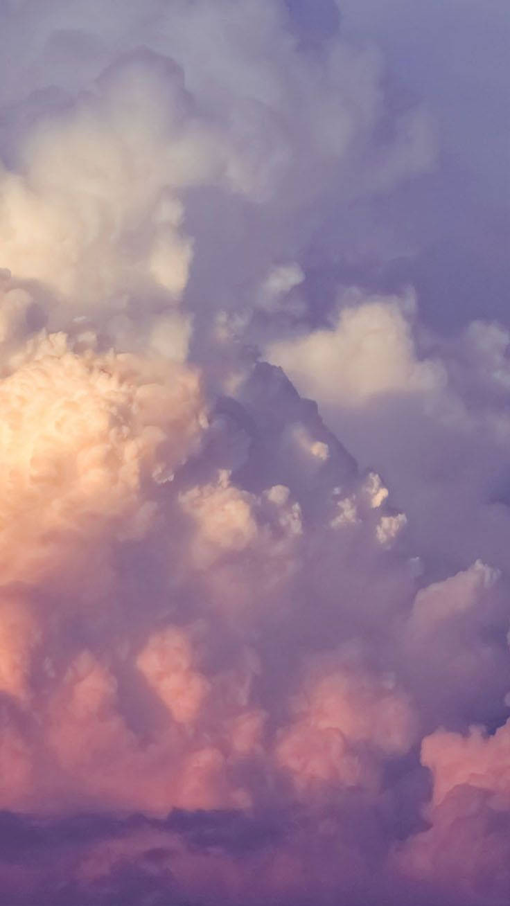 雲朵 桌布 壁紙 — 廣闊的雲彩塗上柔和的粉紅、紫色和金色，在暮色天空中閃耀。