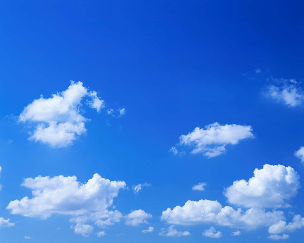 Blue Skies 桌布 壁紙 — 廣闊蔚藍天空，點綴著蓬鬆白色積雲，在明亮日光下。
