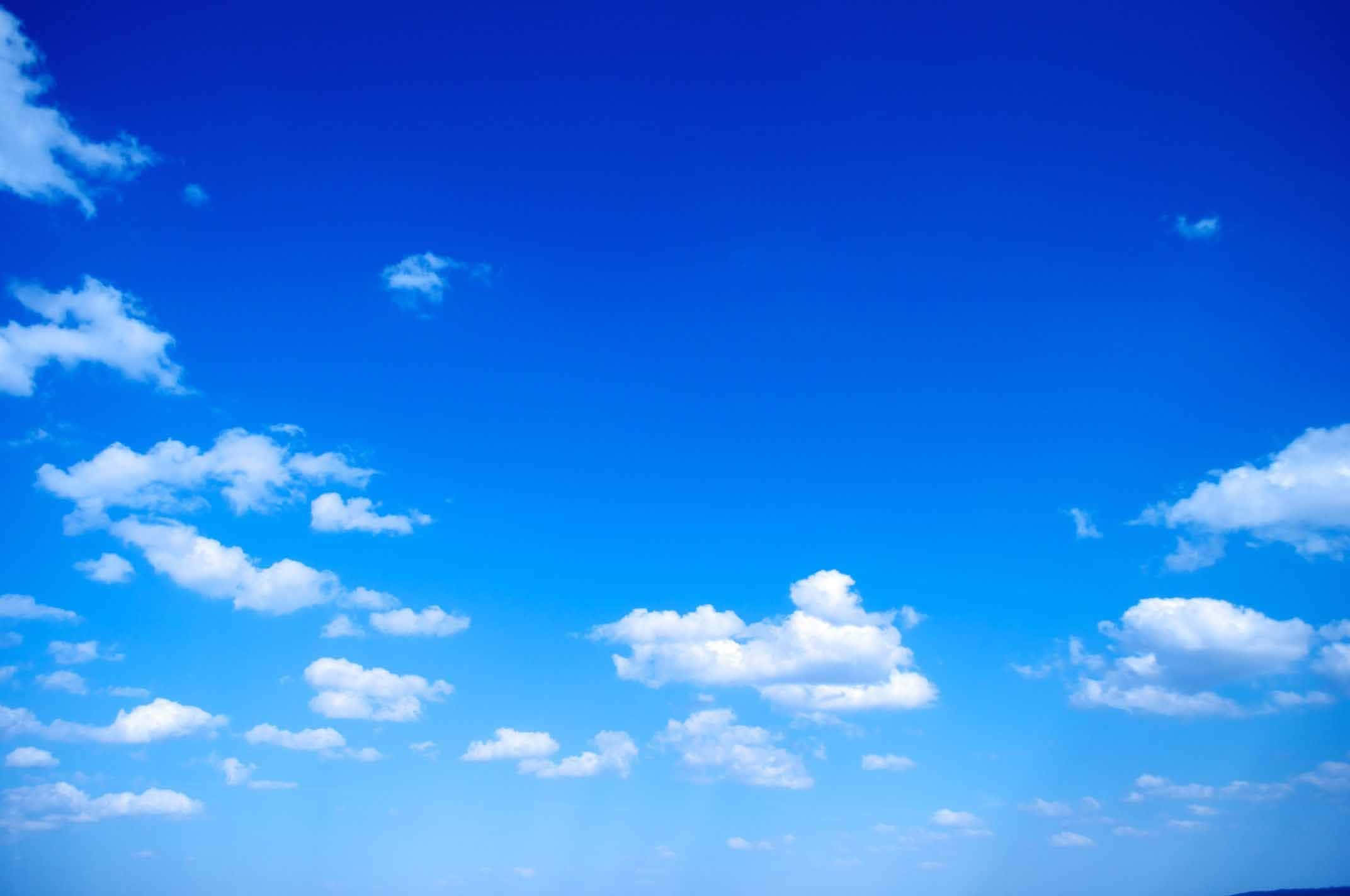 雲朵 桌布 壁紙 — 廣闊蔚藍天空點綴著蓬鬆白雲，在明亮日光下。