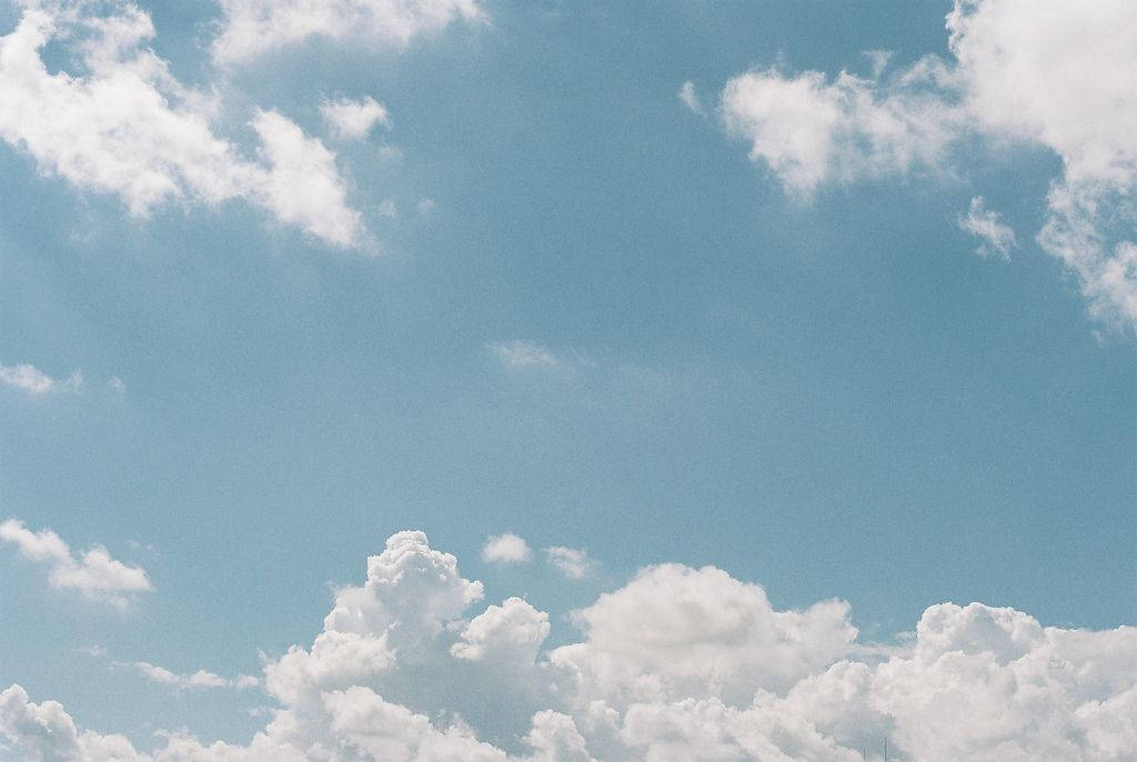桌布 壁紙 — 廣闊蔚藍的天空點綴著蓬鬆的白雲，懶洋洋地在頭頂飄過。