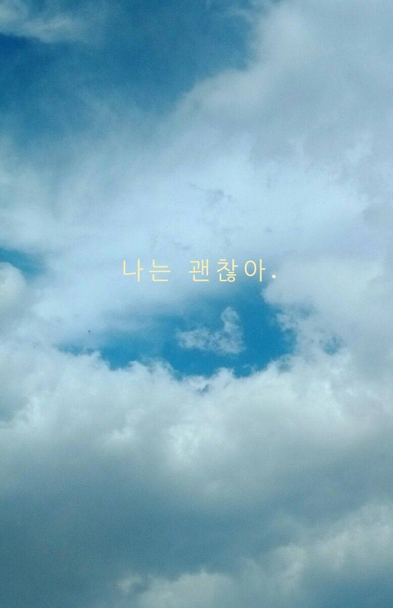 korean 桌布 壁紙 — 廣闊藍天佈滿柔軟白雲，上面覆蓋韓文文字 '나는 괜찮아.'