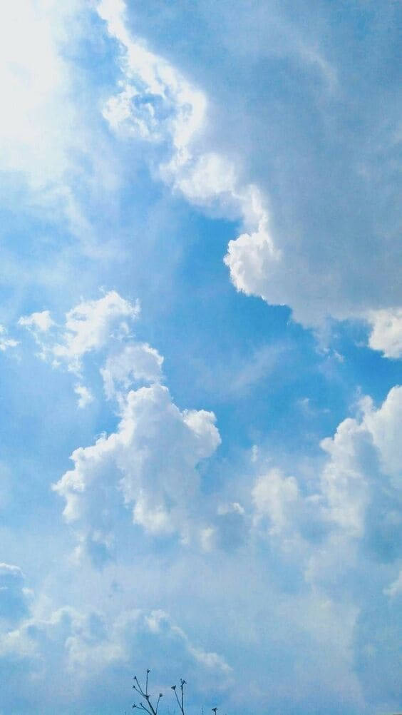 藍色 桌布 壁紙 — 廣闊藍天佈滿蓬鬆白雲，柔和陽光穿過縷縷雲層。
