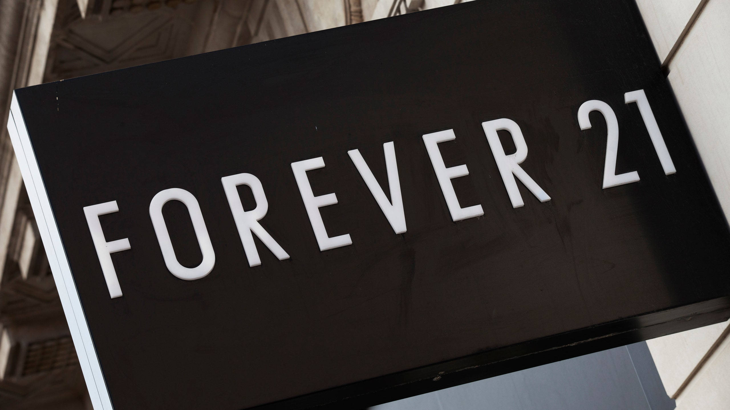 永遠21 桌布 壁紙 — 建築物外牆上安裝的黑色Forever 21商店招牌特寫，帶有粗體白色字體。