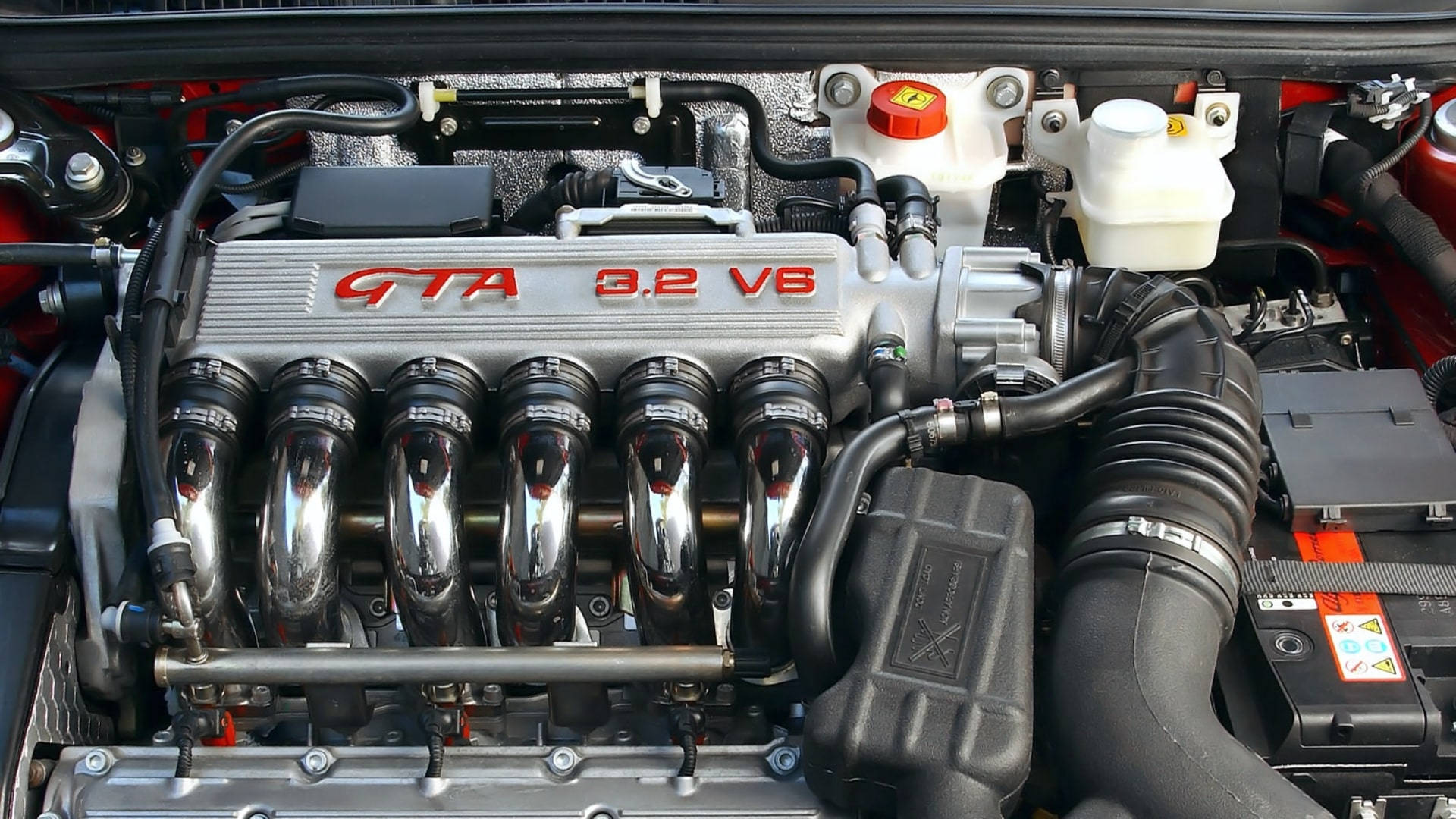 Alfa Romeo 桌布 壁紙 — 引擎蓋下拋光銀色 GTA 3.2 V6 引擎的特寫，帶有鍍鉻進氣歧管和紅色飾邊。