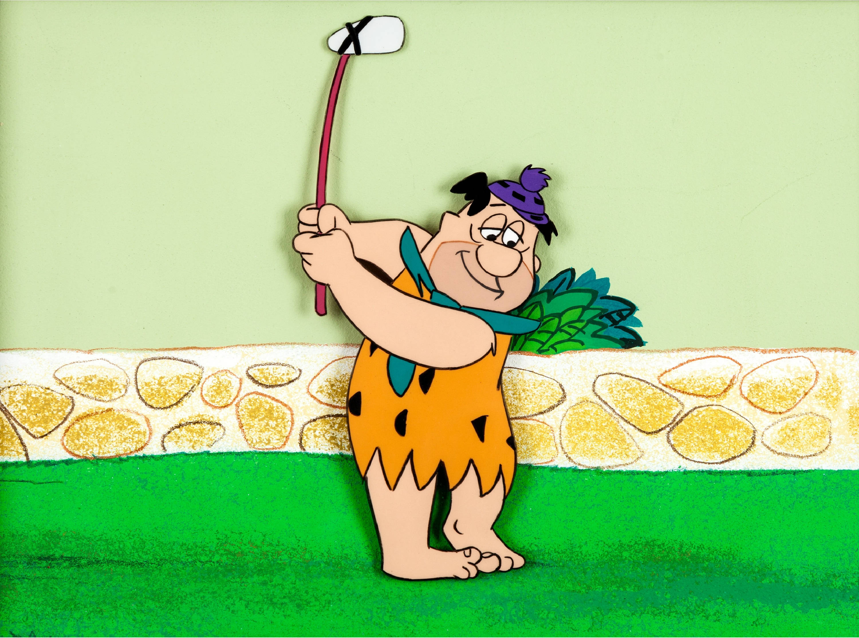 Flintstone 桌布 壁紙 — 弗林斯通在明亮的綠色球場上揮動石器時代的高爾夫球桿，身後有一道石牆。
