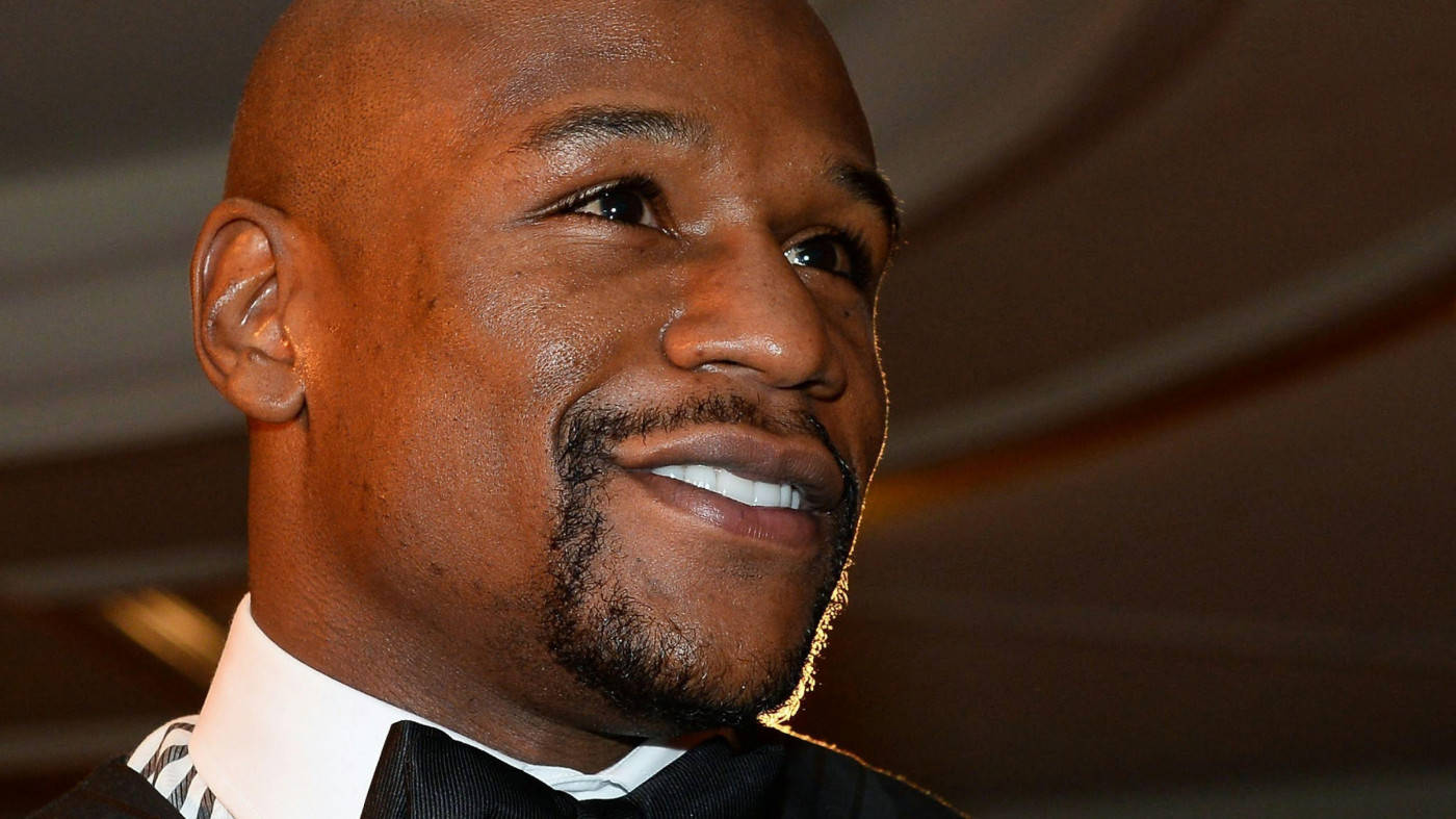 staring 桌布 壁紙 — 弗洛伊德·梅威瑟（Floyd Mayweather Jr.）在柔和室內燈光下穿著燕尾服，溫暖微笑的特寫肖像。