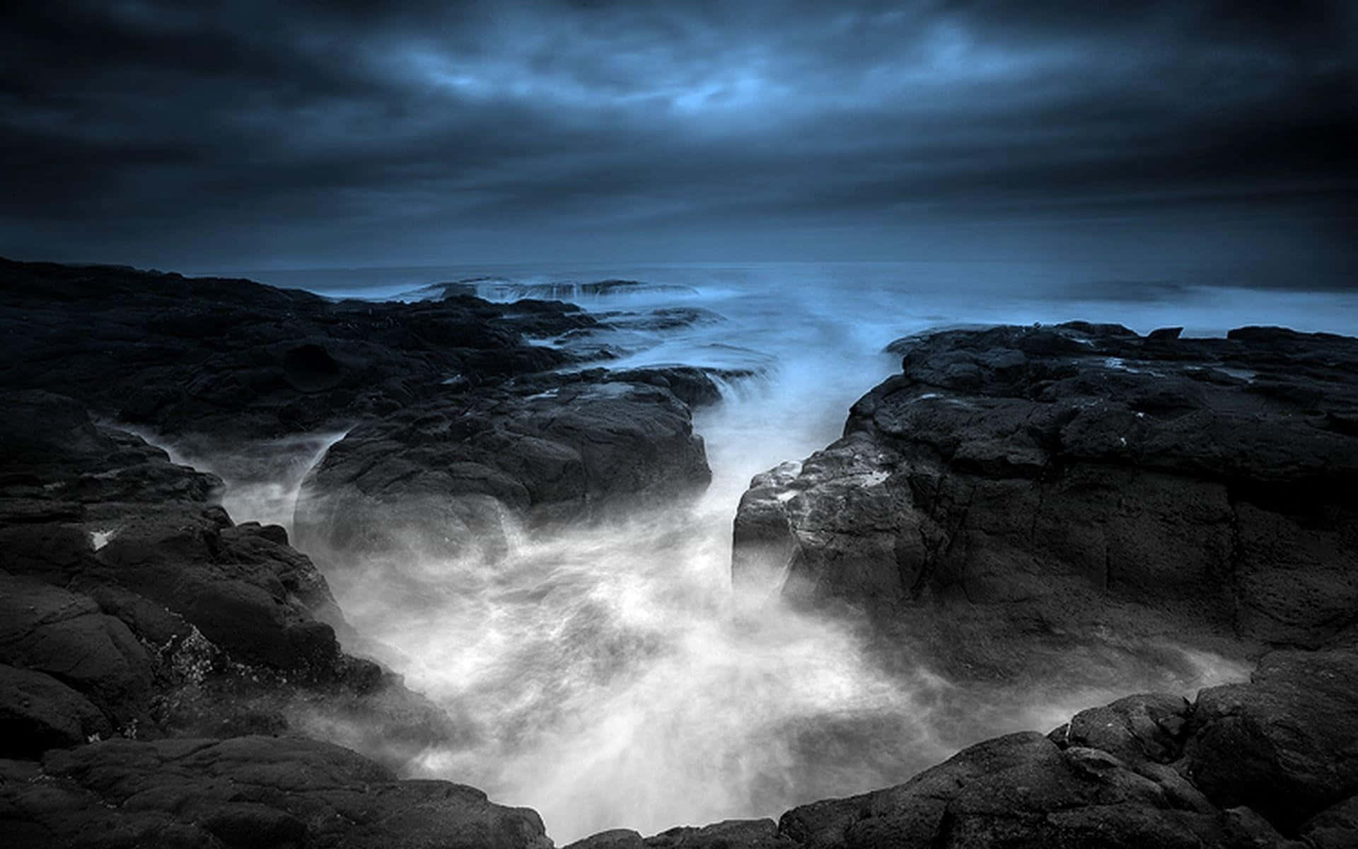 Mystical 桌布 壁紙 — 強勁的海浪在陰沉的黃昏天空下衝擊著鋸齒狀的黑色岩石。