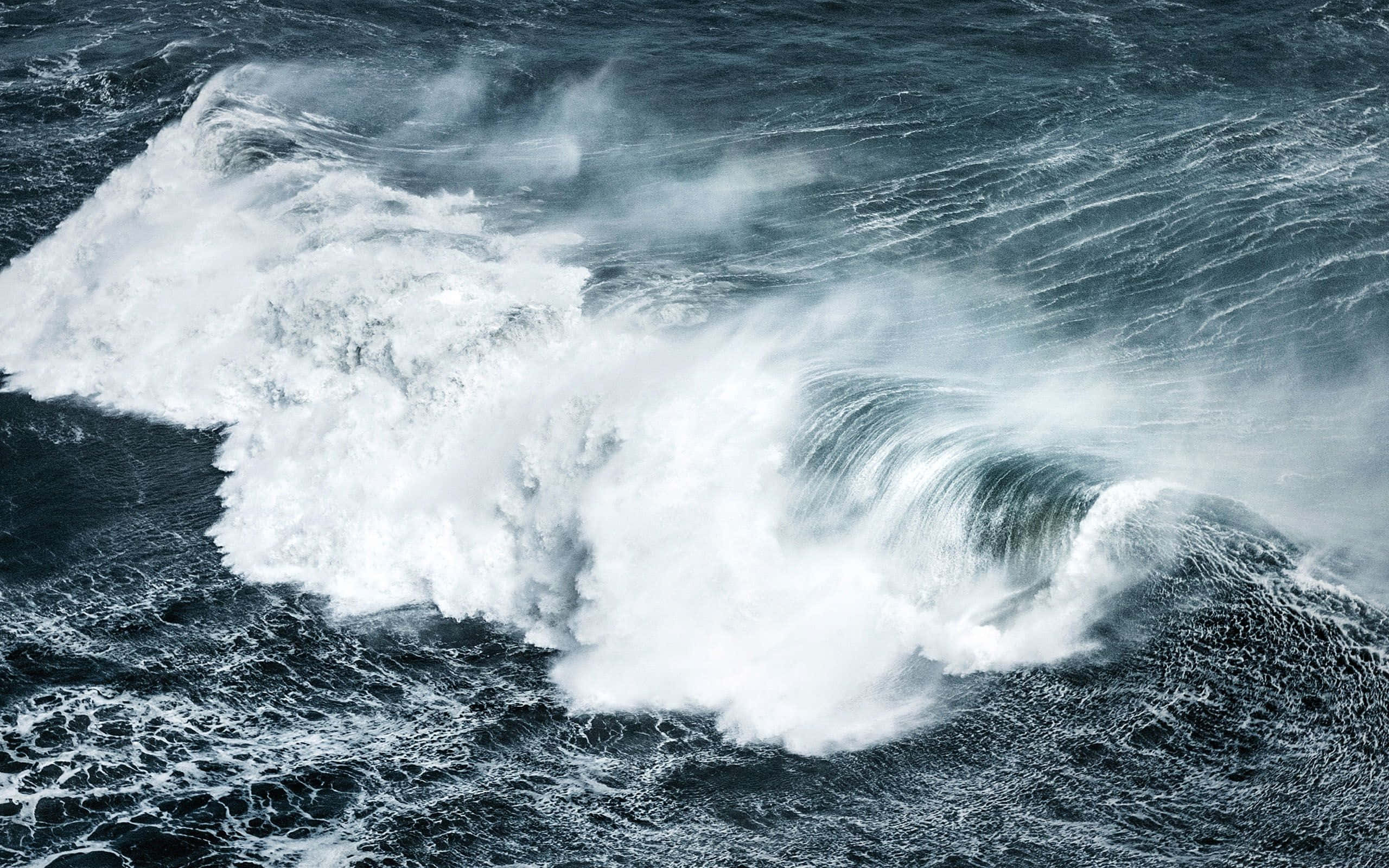 Ocean Waves 桌布 壁紙 — 強勁的海浪拍打著白色泡沫，撞向黑暗翻滾的海水，呈現戲劇性的空中視角。