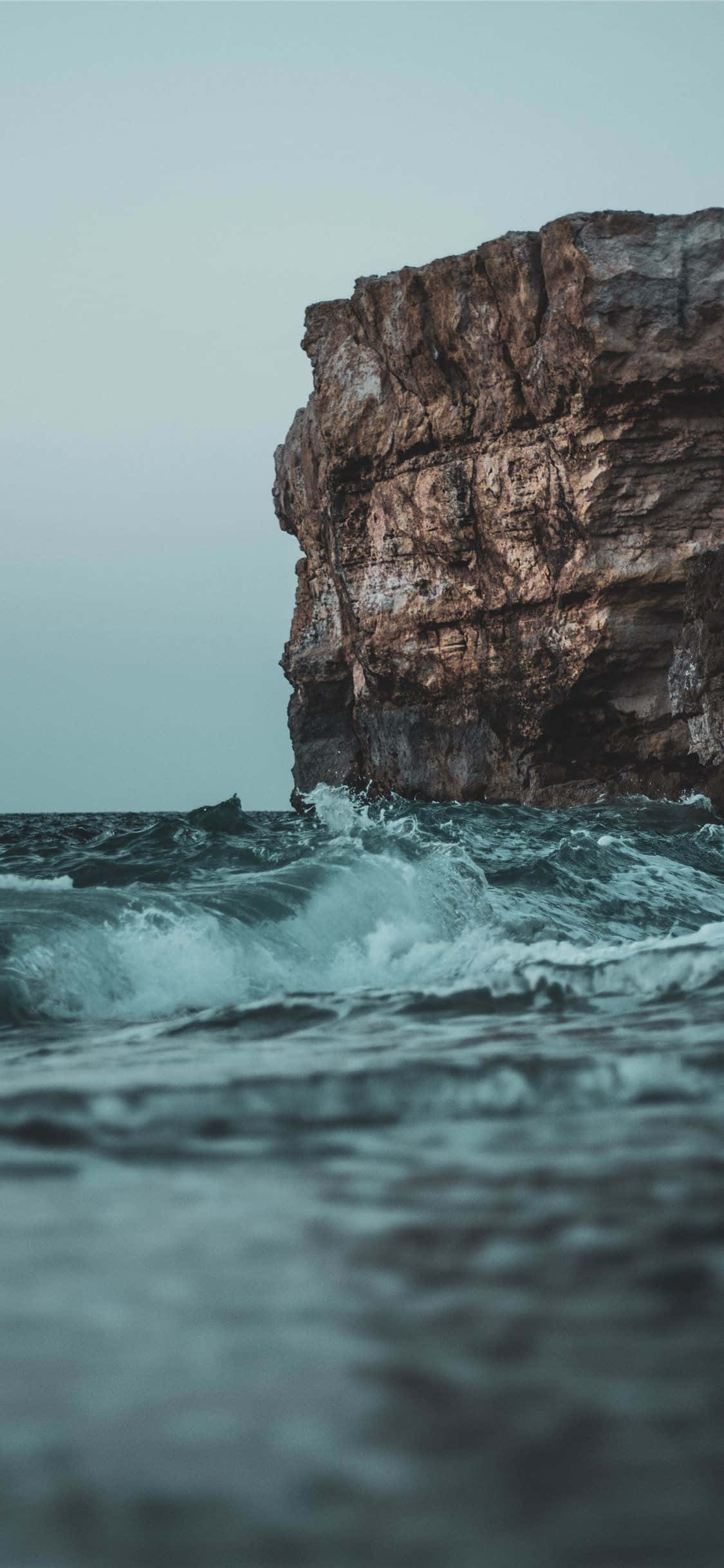 Wave 桌布 壁紙 — 強大的海浪在陰沉天空下拍打著高聳崎嶇的懸崖。