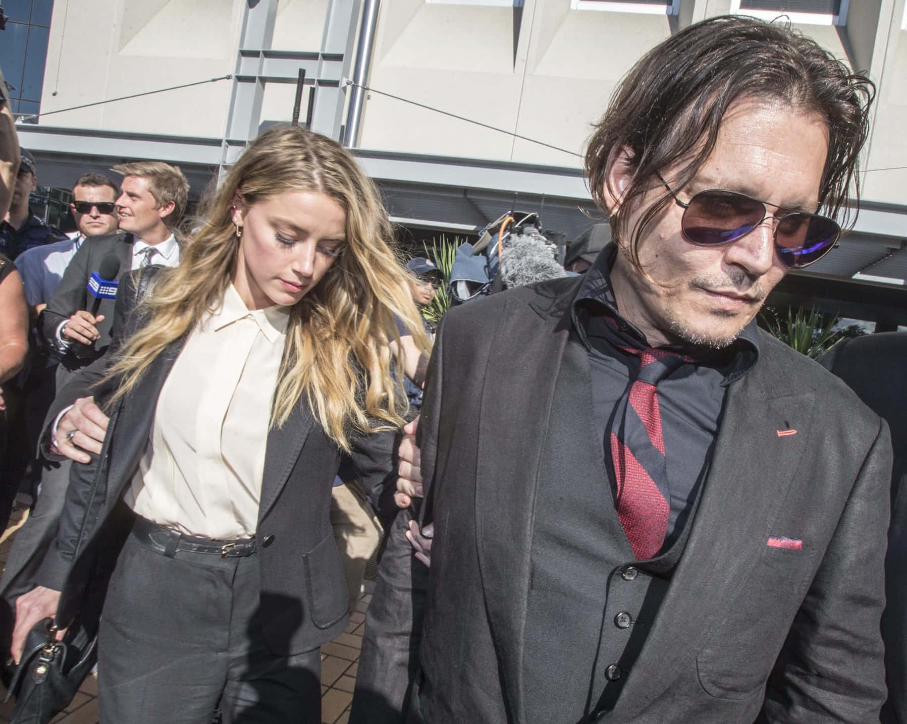 Johnny Depp And Amber Heard 桌布 壁紙 — 強尼戴普和安柏赫德一起穿過現代建築外的人群，當中包括記者和攝影機。