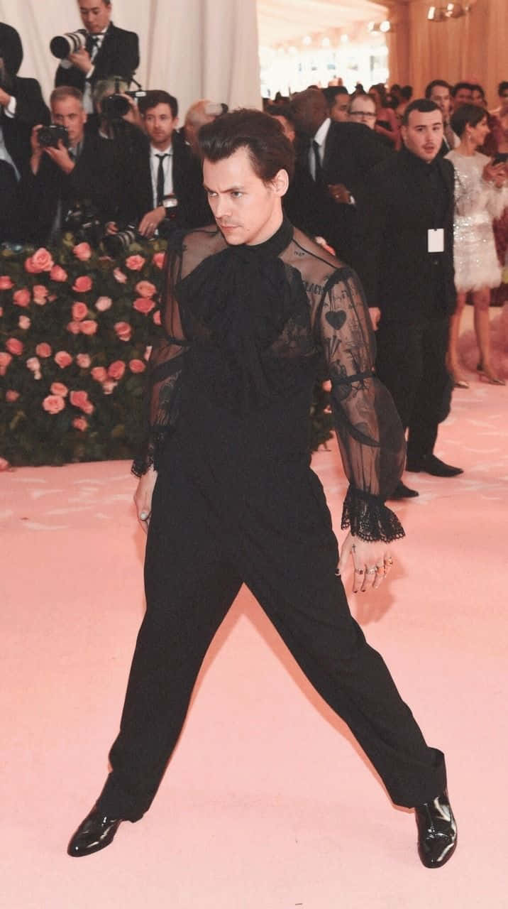 Met Gala 桌布 壁紙 — 強尼戴普在粉紅地毯上穿著透視黑色服裝，被攝影師和花卉佈置包圍，擺出大膽姿勢。