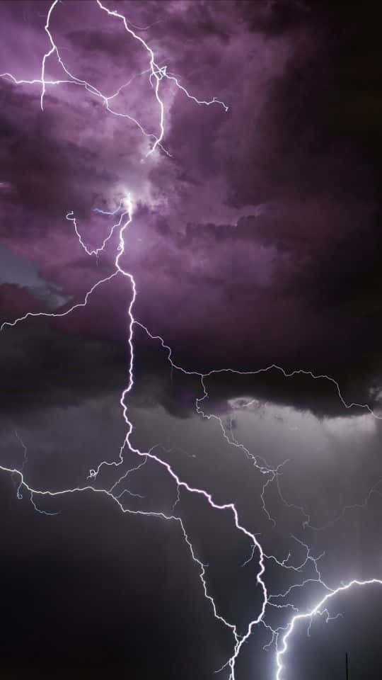 Cool Lightning 桌布 壁紙 — 強烈的閃電在戲劇性的紫色暴風雨天空中劈啪作響，伴隨著烏雲。