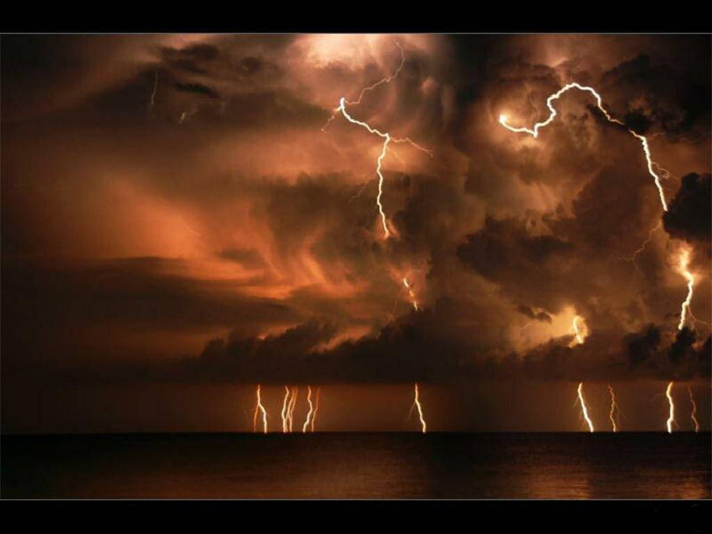 暴風 桌布 壁紙 — 強烈的閃電在黑暗海洋地平線上的暴風雨橙色天空中劈啪作響。