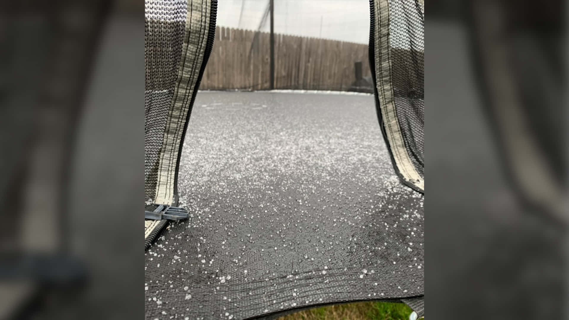 雪 桌布 壁紙 — 彈跳床表面近景，上面散落著雪花，背景是木柵欄。