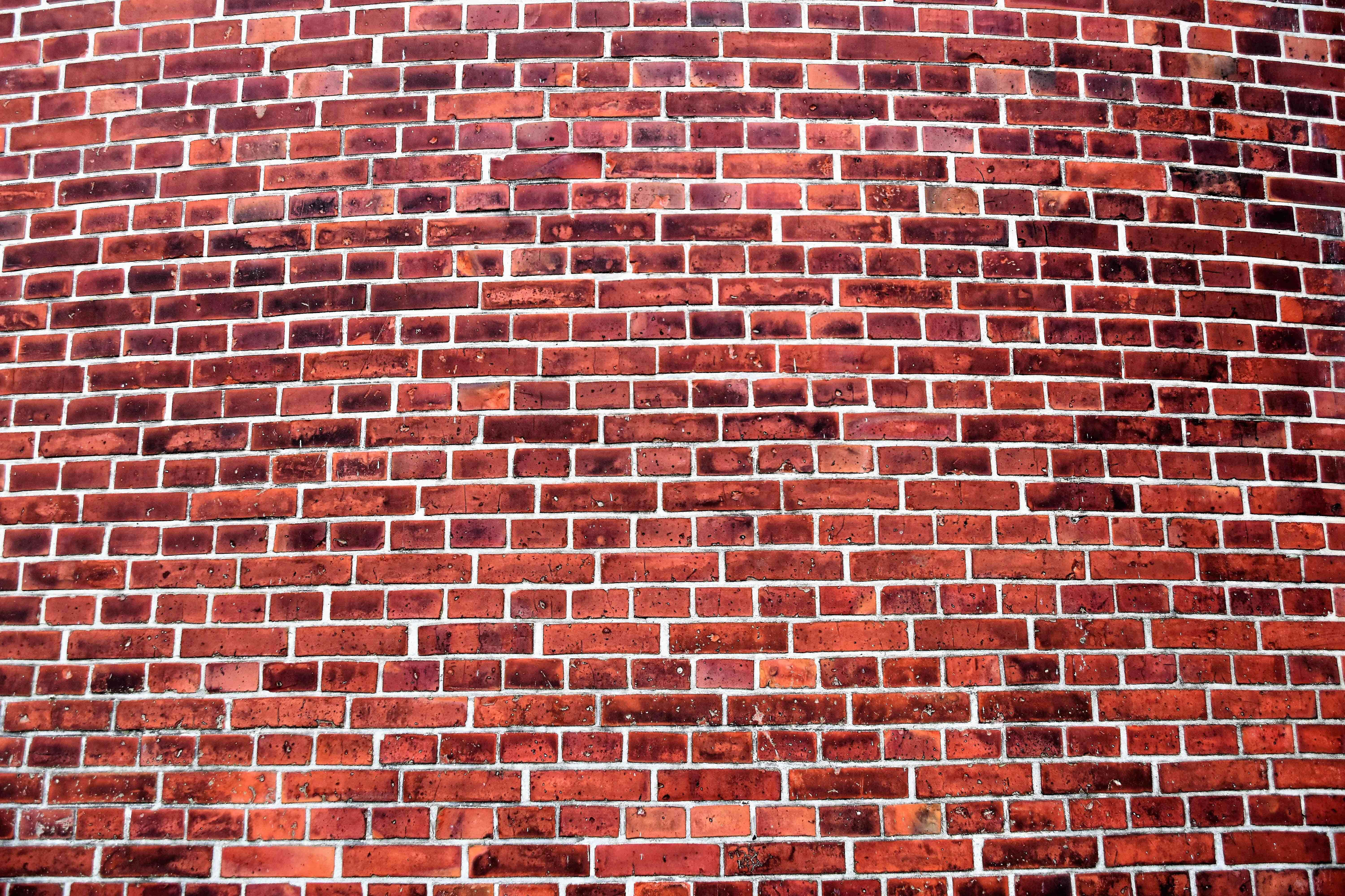 Brick Wall 桌布 壁紙 — 彎曲紅磚牆的特寫，帶有白色砂漿線，顯示紋理和風化細節。