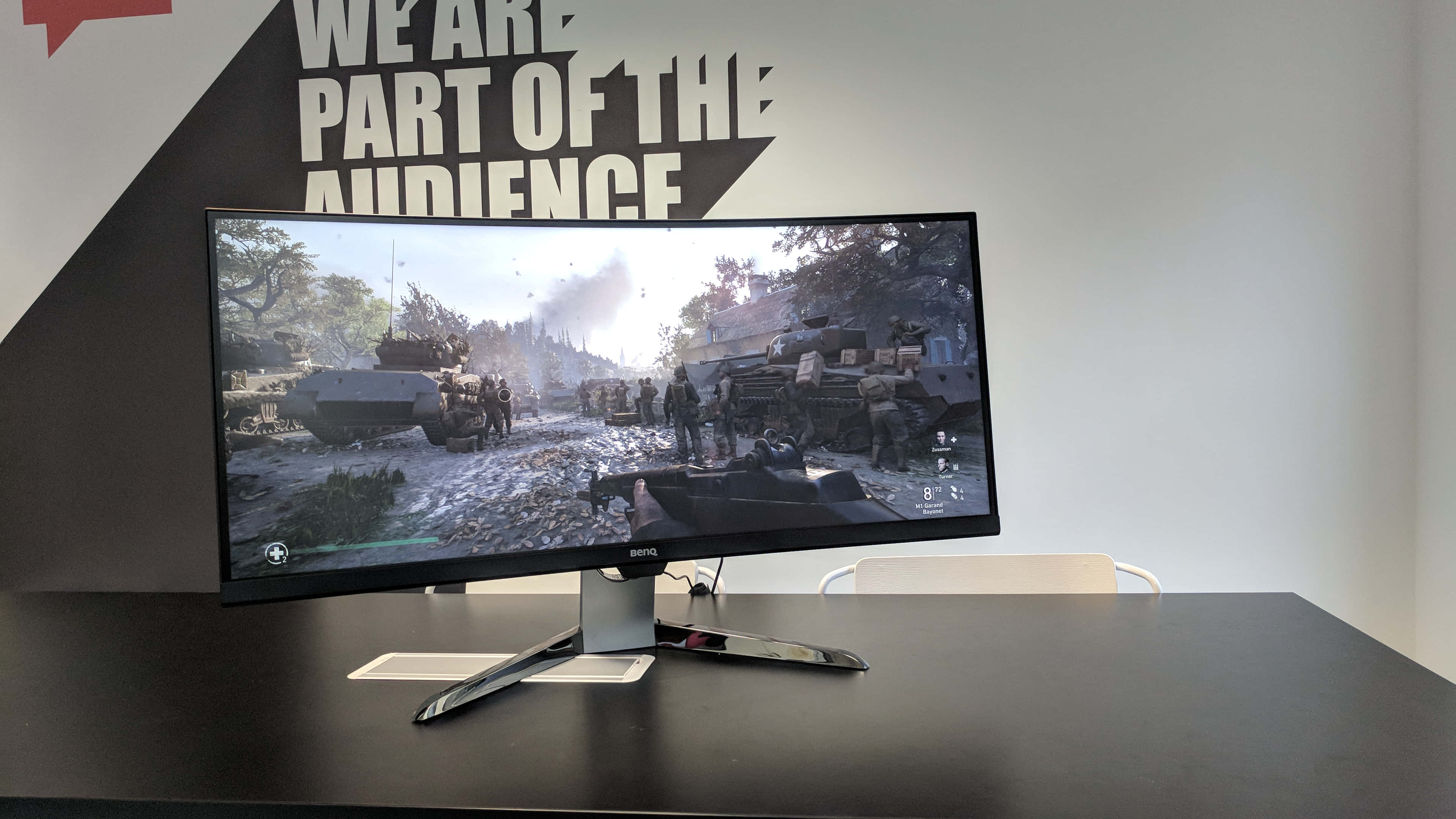 Gaming Monitors 桌布 壁紙 — 彎曲遊戲顯示器顯示煙霧瀰漫的天空下，坦克和士兵在戰場上的場景。