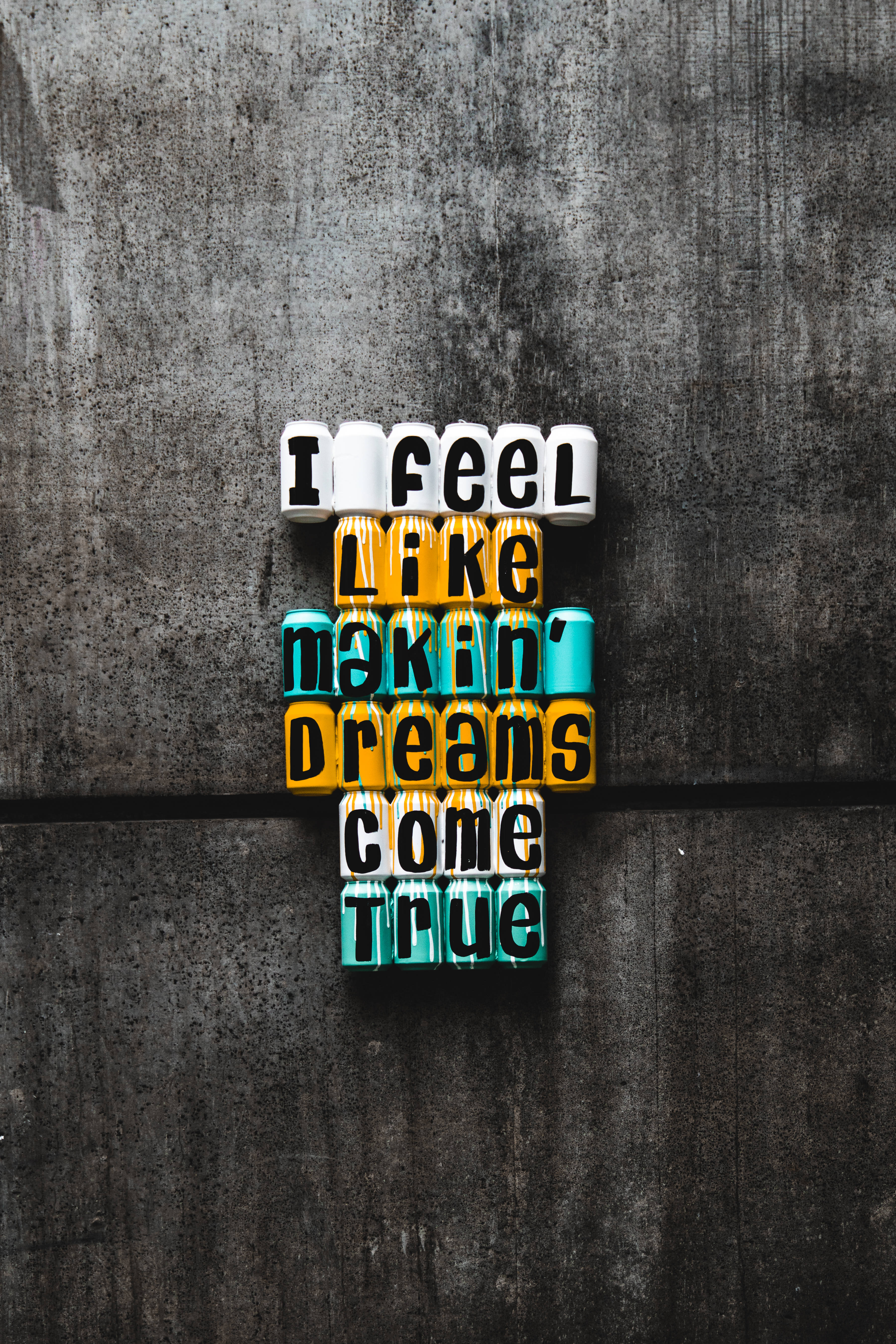 激勵 桌布 壁紙 — 彩色字母積木在紋理灰色混凝土牆上拼出「I feel like makin' dreams come true」。