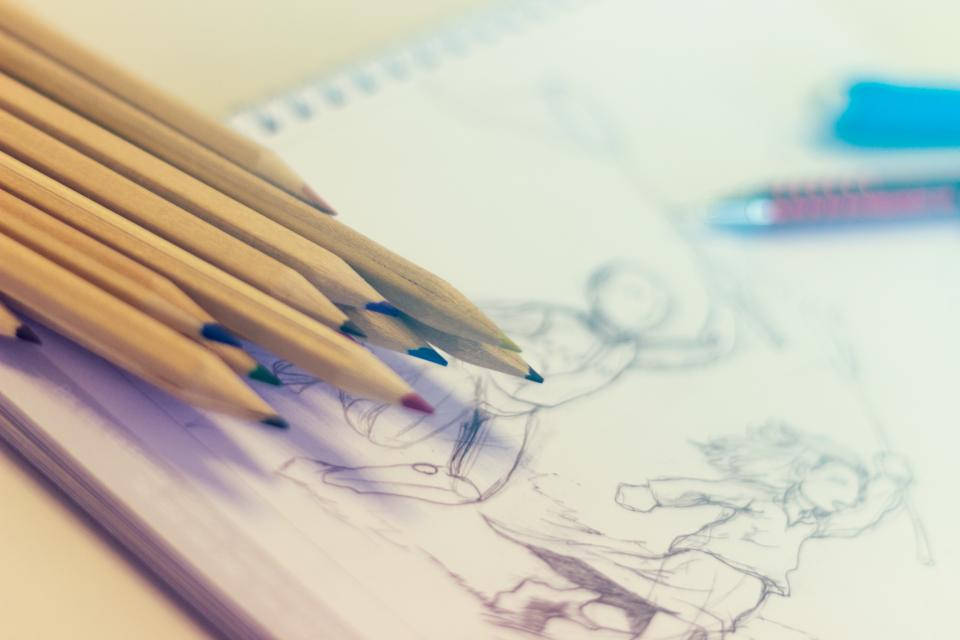 pencil 桌布 壁紙 — 彩色鉛筆的特寫，放在一本有動漫角色繪圖的素描本上，背景柔和。