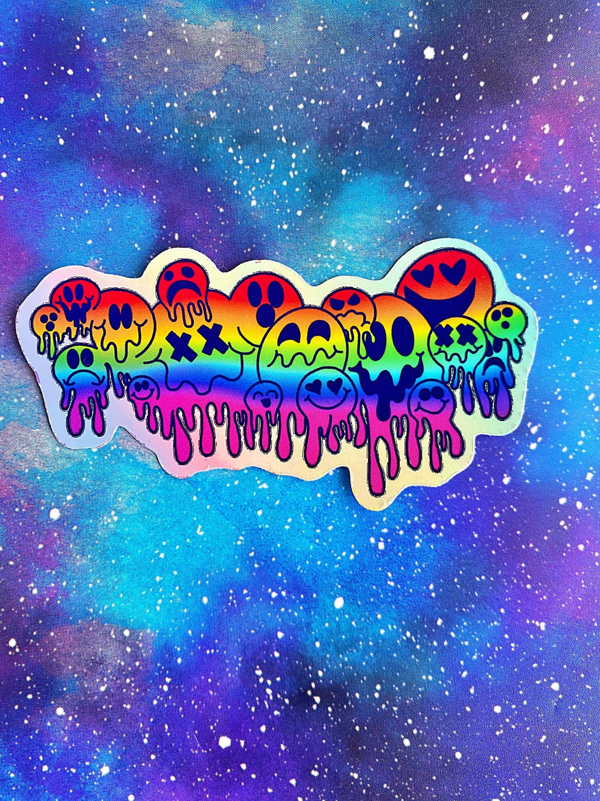 Aesthetic Trippy Smiley Face 桌布 壁紙 — 彩虹漸變貼紙，帶有融化笑臉滴落，背景是宇宙星雲。