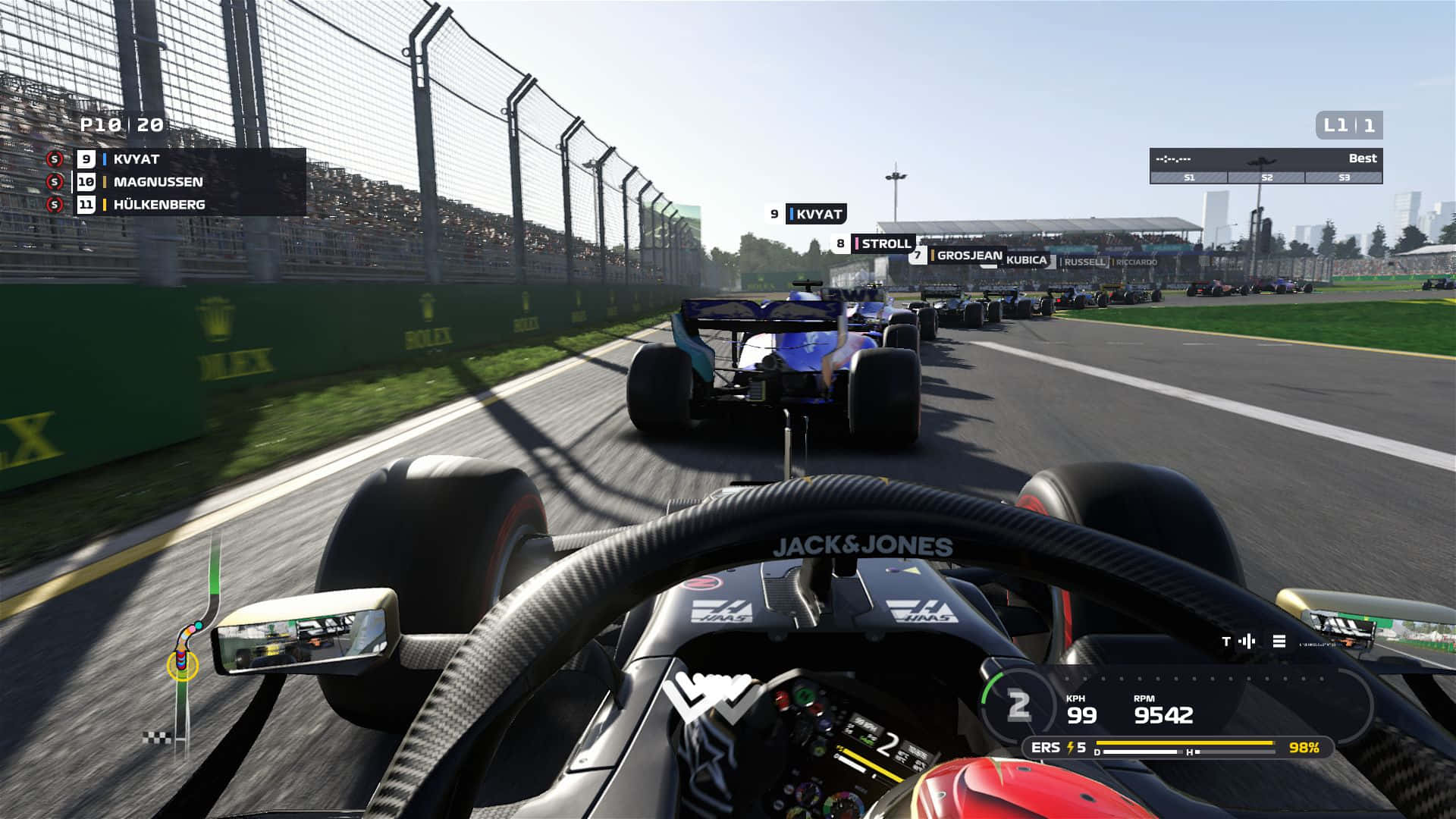Formula 1 桌布 壁紙 — 從一級方程式賽車內部以第一人稱視角觀看，在陽光明媚的賽道上比賽，背景有其他賽車和人群。