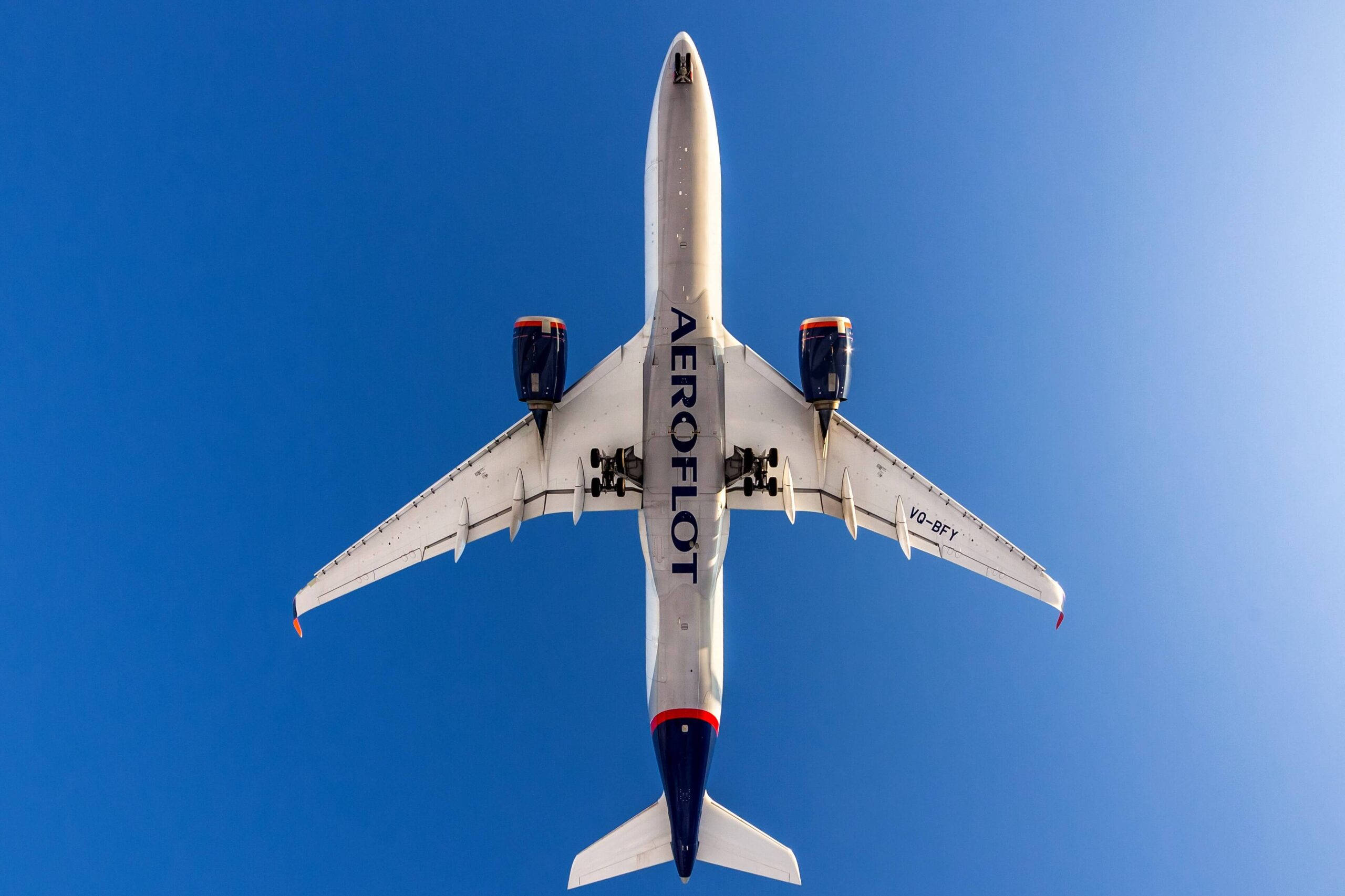 transportation 桌布 壁紙 — 從上往下俯瞰一架俄羅斯航空飛機在清澈藍天中翱翔。