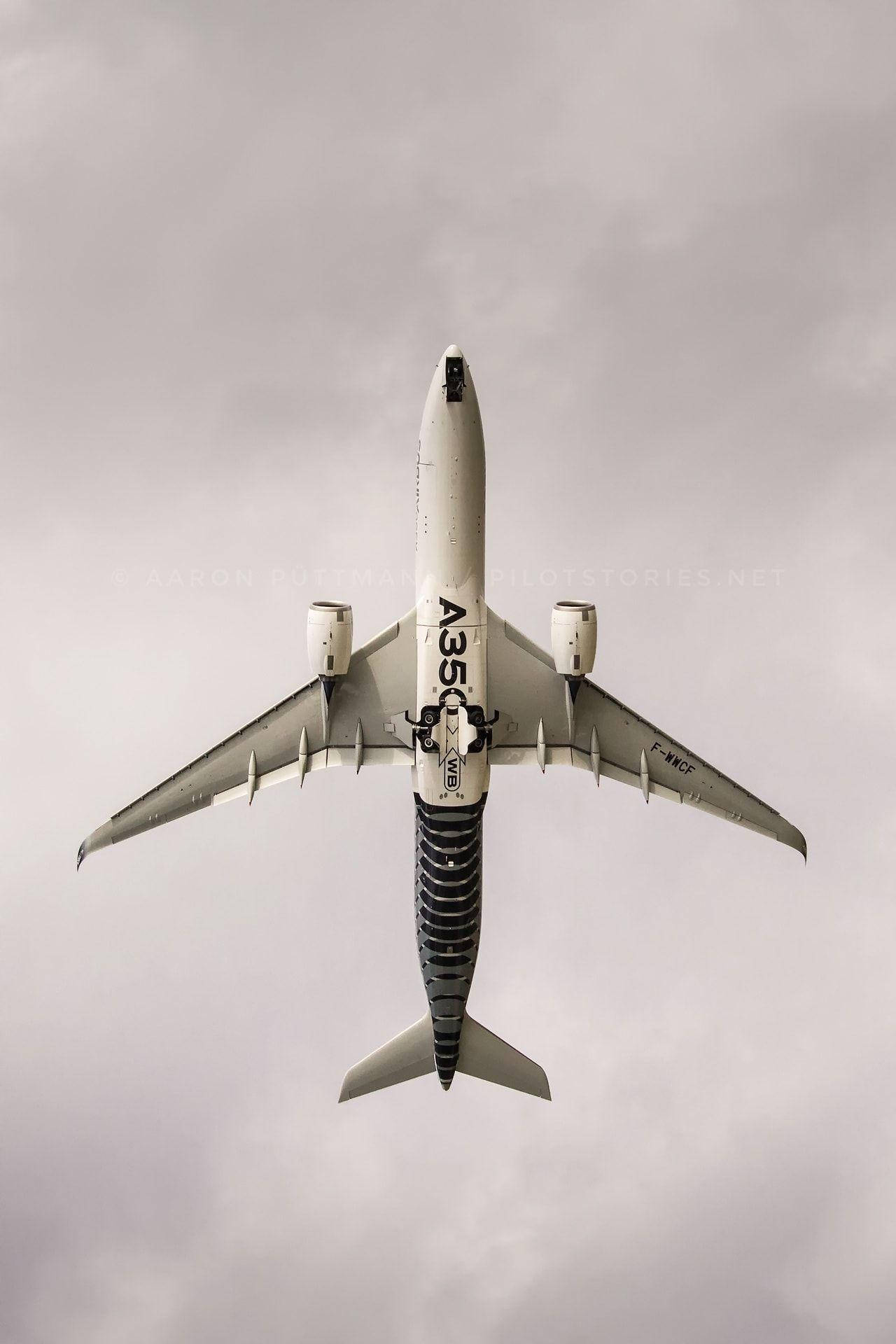 從上方觀看空中巴士A350飛機，背景為多雲天空。