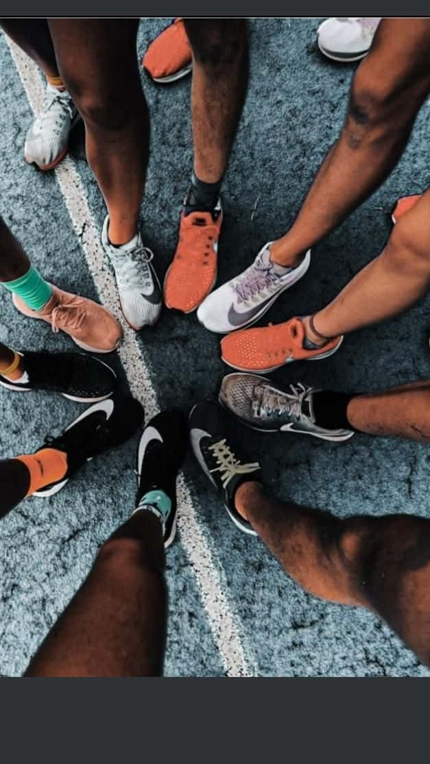 Friends 桌布 壁紙 — 從上方俯瞰，不同跑者穿著色彩繽紛的運動鞋，擠在帶有紋理的跑道上。