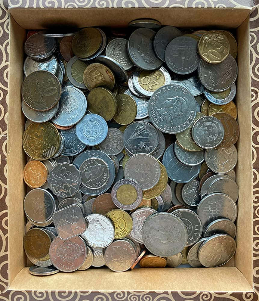 Coins 桌布 壁紙 — 從上方俯瞰一個裝滿各種金屬和設計的國際硬幣的紙箱。