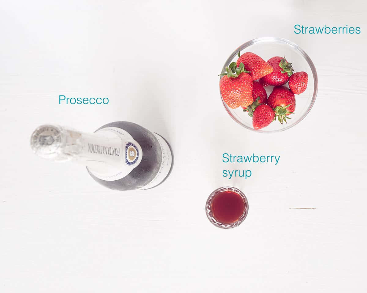 Strawberries 桌布 壁紙 — 從上方俯瞰一瓶普羅賽克氣泡酒、一碗新鮮草莓和一小杯草莓糖漿放在白色表面上。
