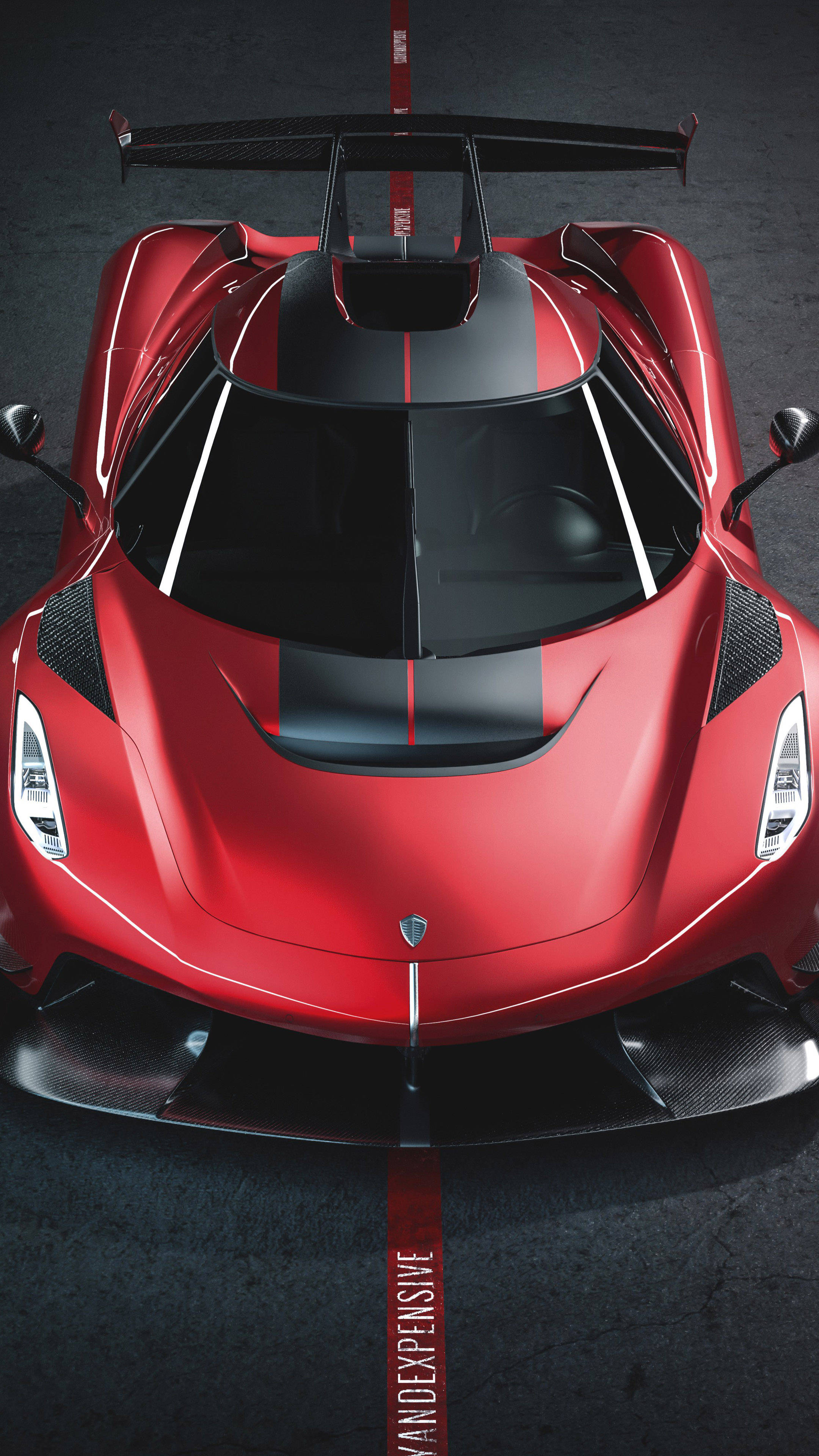 4K HD mobile 桌布 壁紙 — 從上方俯瞰一輛光澤紅色科尼賽克超跑，帶有黑色飾件和大尾翼，停在深色紋理地板上。