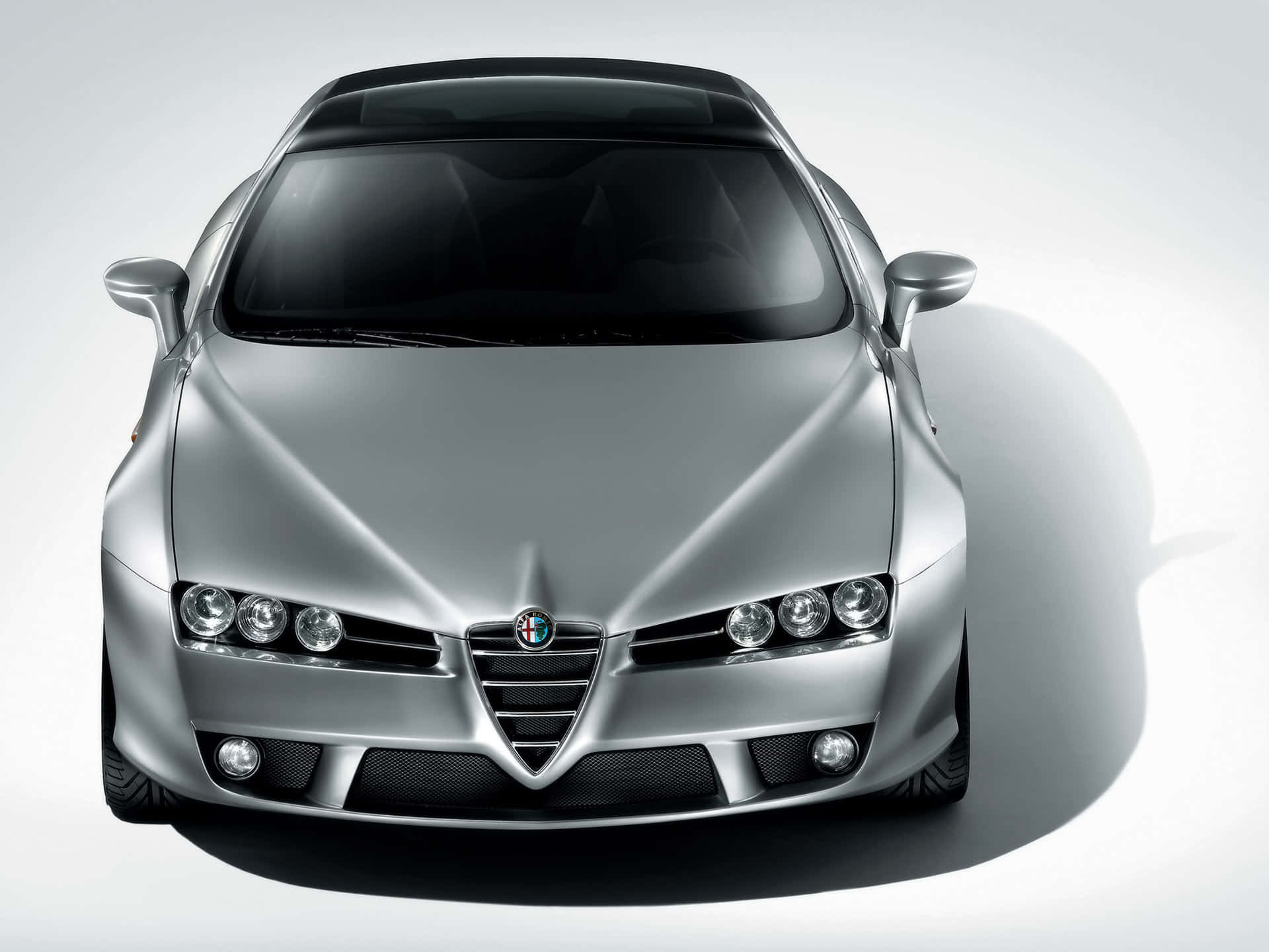 Alfa Romeo Brera 桌布 壁紙 — 從上方俯瞰一輛時尚的銀色愛快羅密歐跑車，背景為簡約的白色攝影棚。