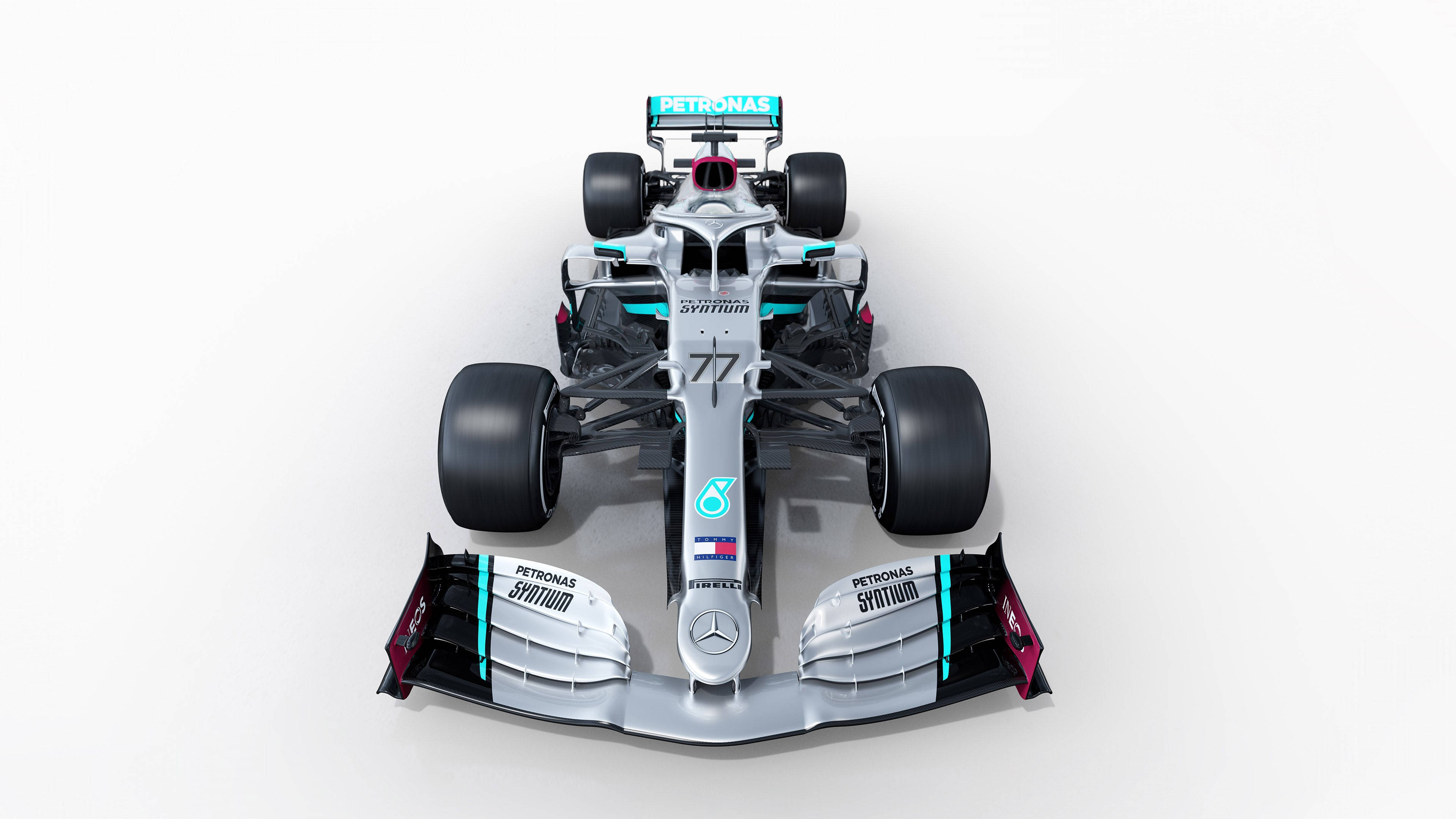 Mercedes 桌布 壁紙 — 從上方俯瞰一輛銀色和藍綠色的 Formula 1 賽車，車號 77，背景為純白色。