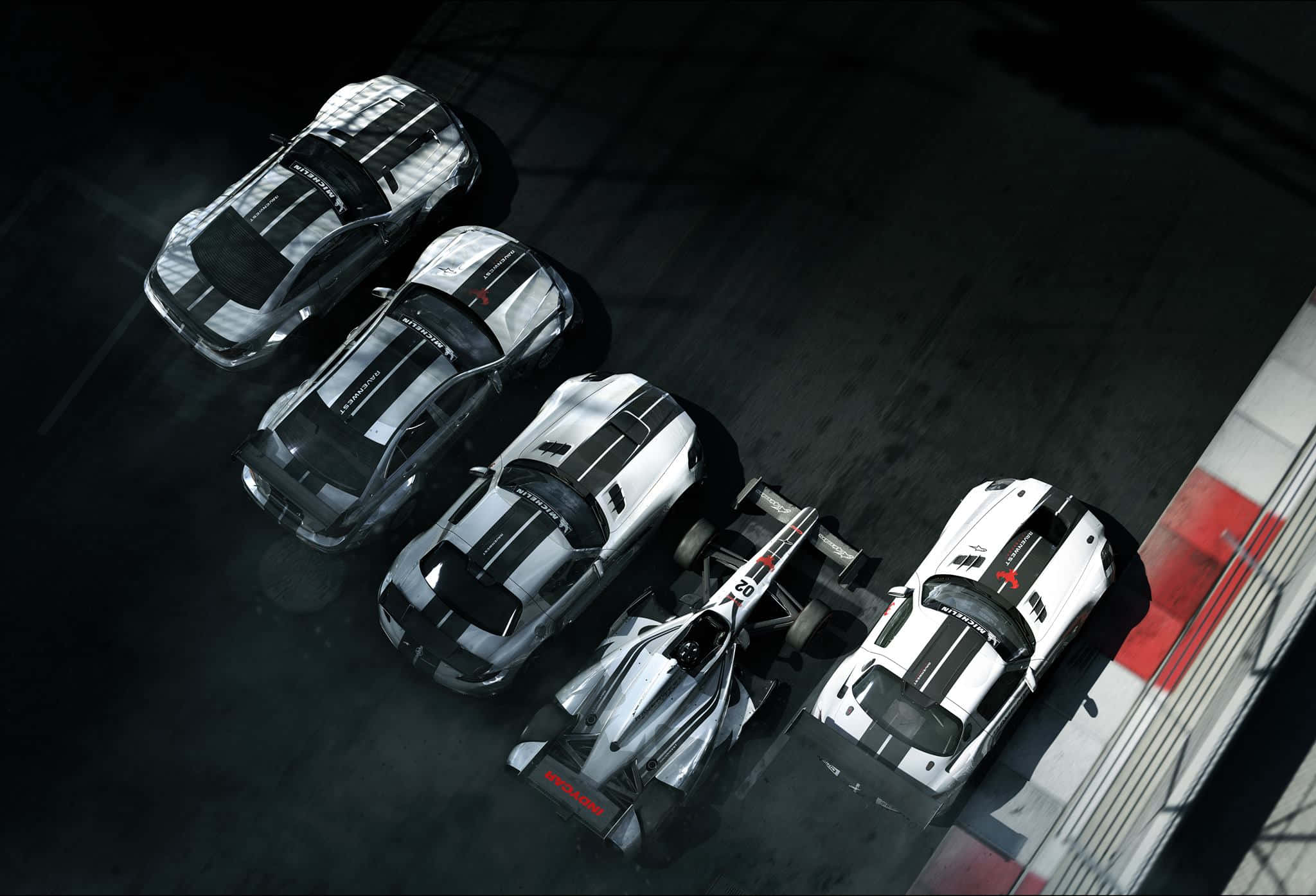 1080p Grid Autosport 桌布 壁紙 — 從上方俯瞰五輛高性能賽車排列在帶有紅色和白色路緣的黑暗賽道上。