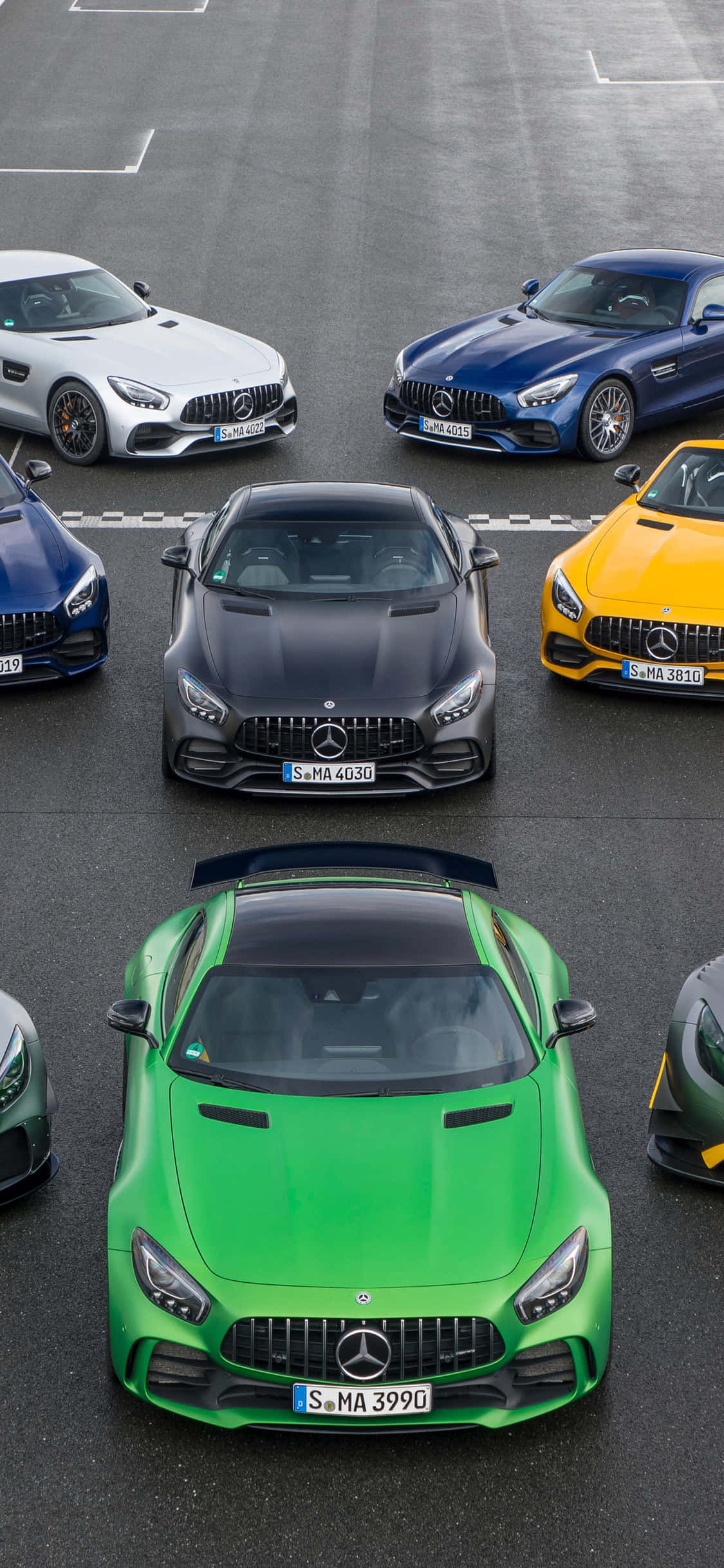iPhone X Amg Gt-r 桌布 壁紙 — 從上方俯瞰六輛高性能 Mercedes-AMG GT 跑車以網格形式停放在灰色瀝青場地上。