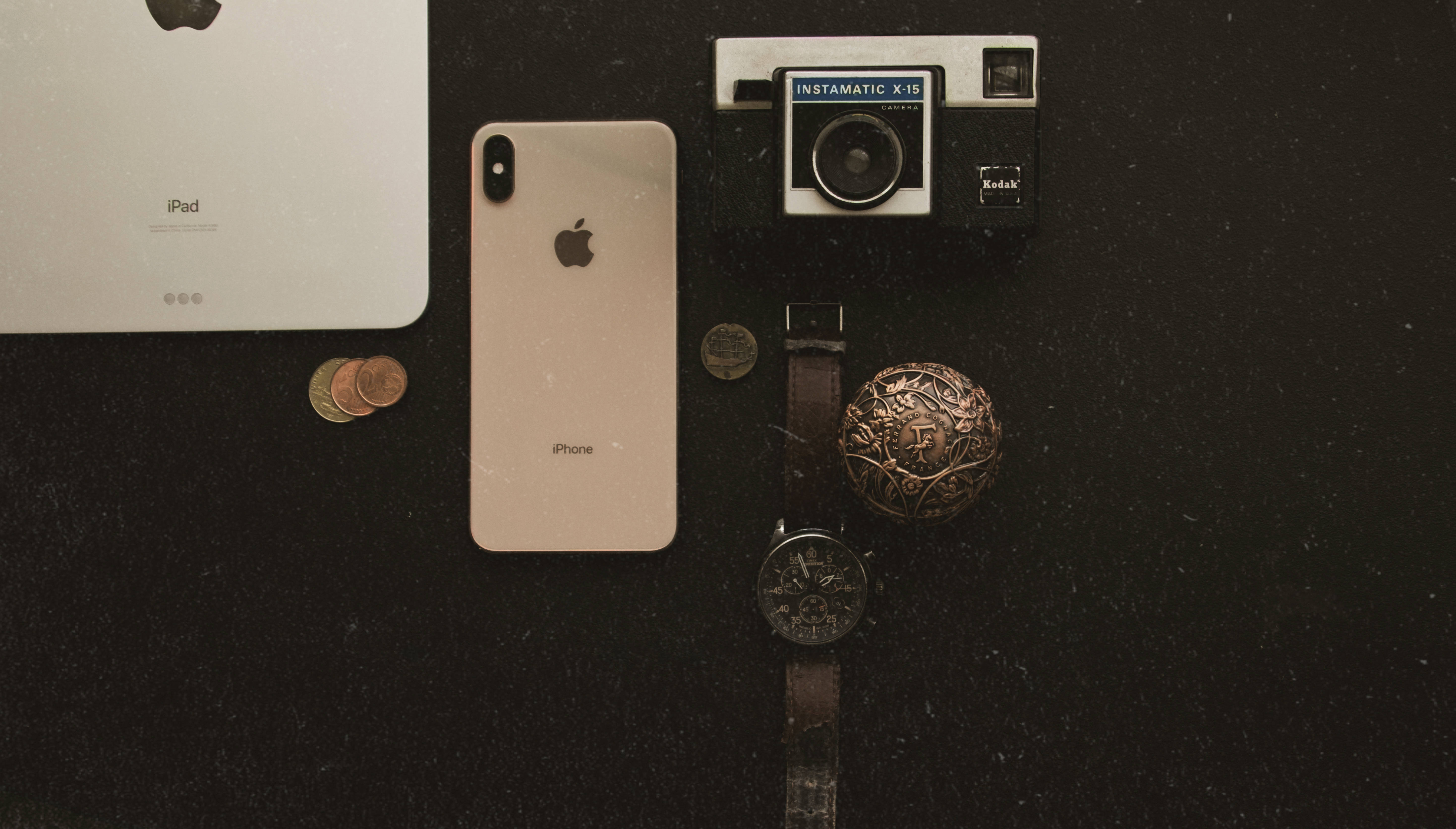 iPhone Xs Max 桌布 壁紙 — 從上方俯瞰復古與現代科技小工具排列在深色紋理表面上的視圖。