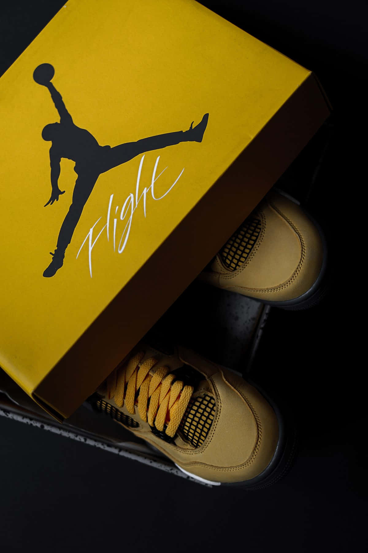 鞋子 桌布 壁紙 — 從上方俯瞰的視角，展示淺褐色 Jordan 運動鞋及其鮮黃色鞋盒，鞋盒上帶有標誌性的 Jumpman 標誌和 'Flight' 字樣。