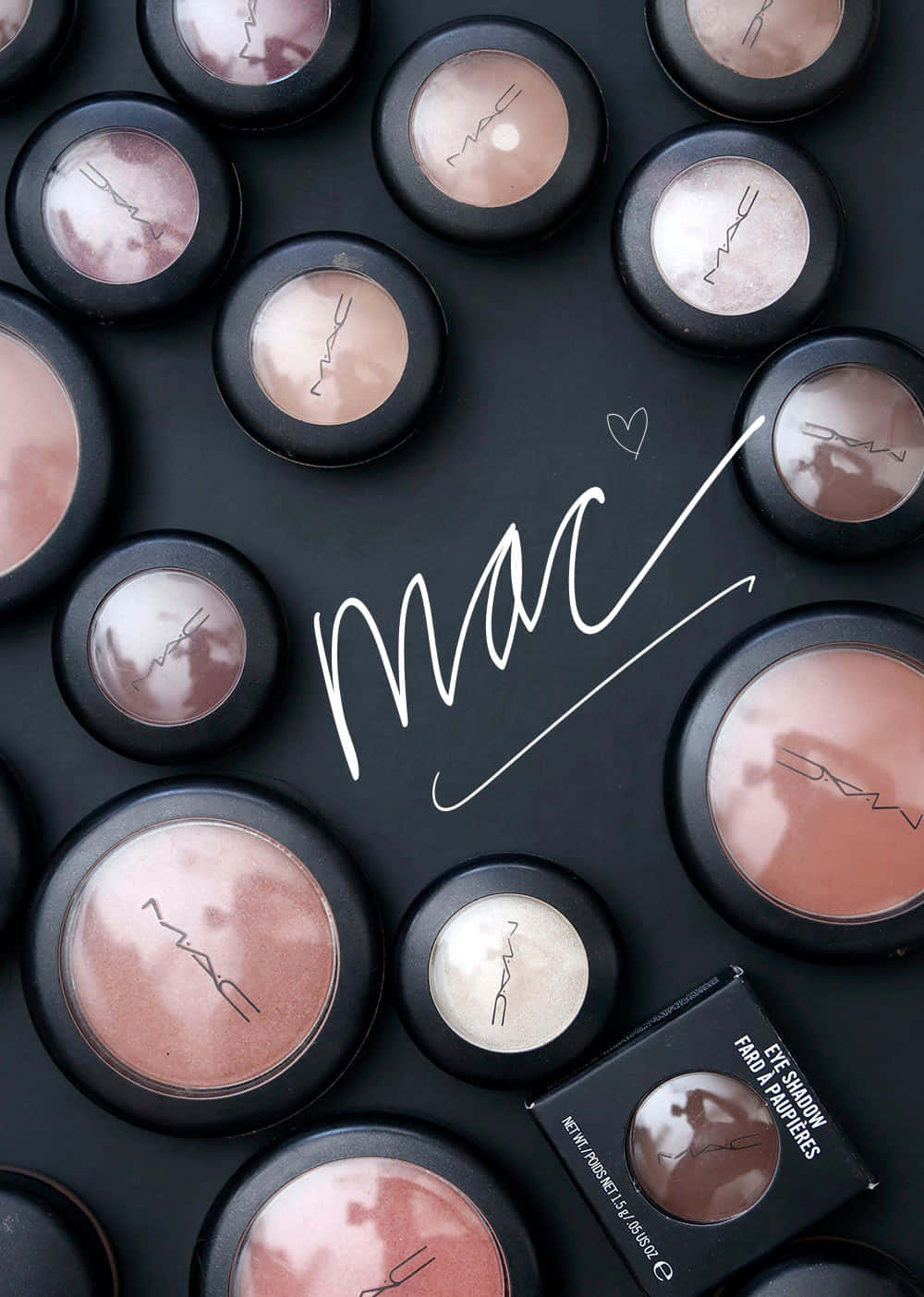 Mac Cosmetics 桌布 壁紙 — 從上方拍攝的MAC眼影盤，玫瑰金和裸色調排列在黑色背景上，帶有手寫的「mac」字樣。