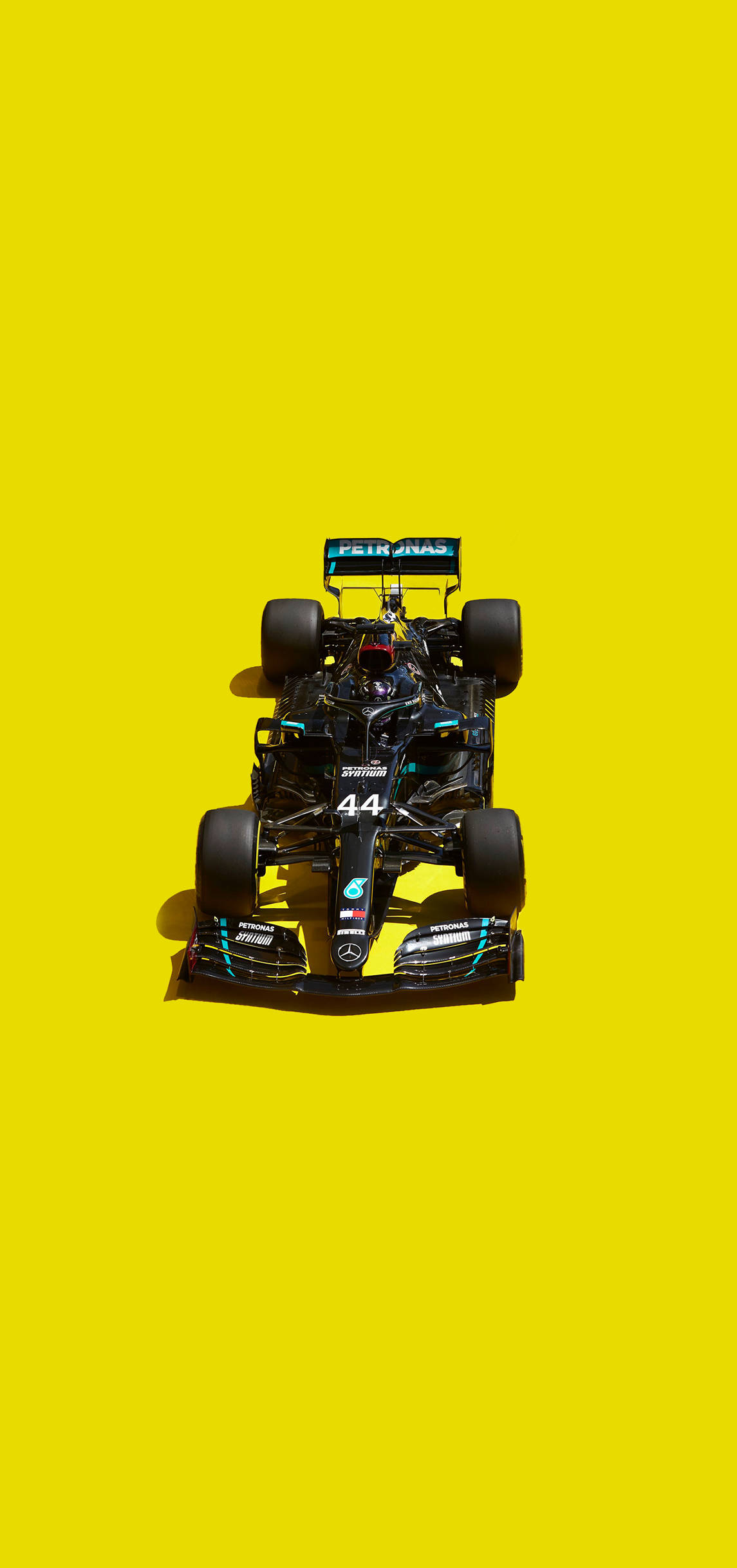 Mercedes 桌布 壁紙 — 從上方觀看，一輛帶有44號和Petronas品牌標誌的黑色一級方程式賽車，背景為純亮黃色。