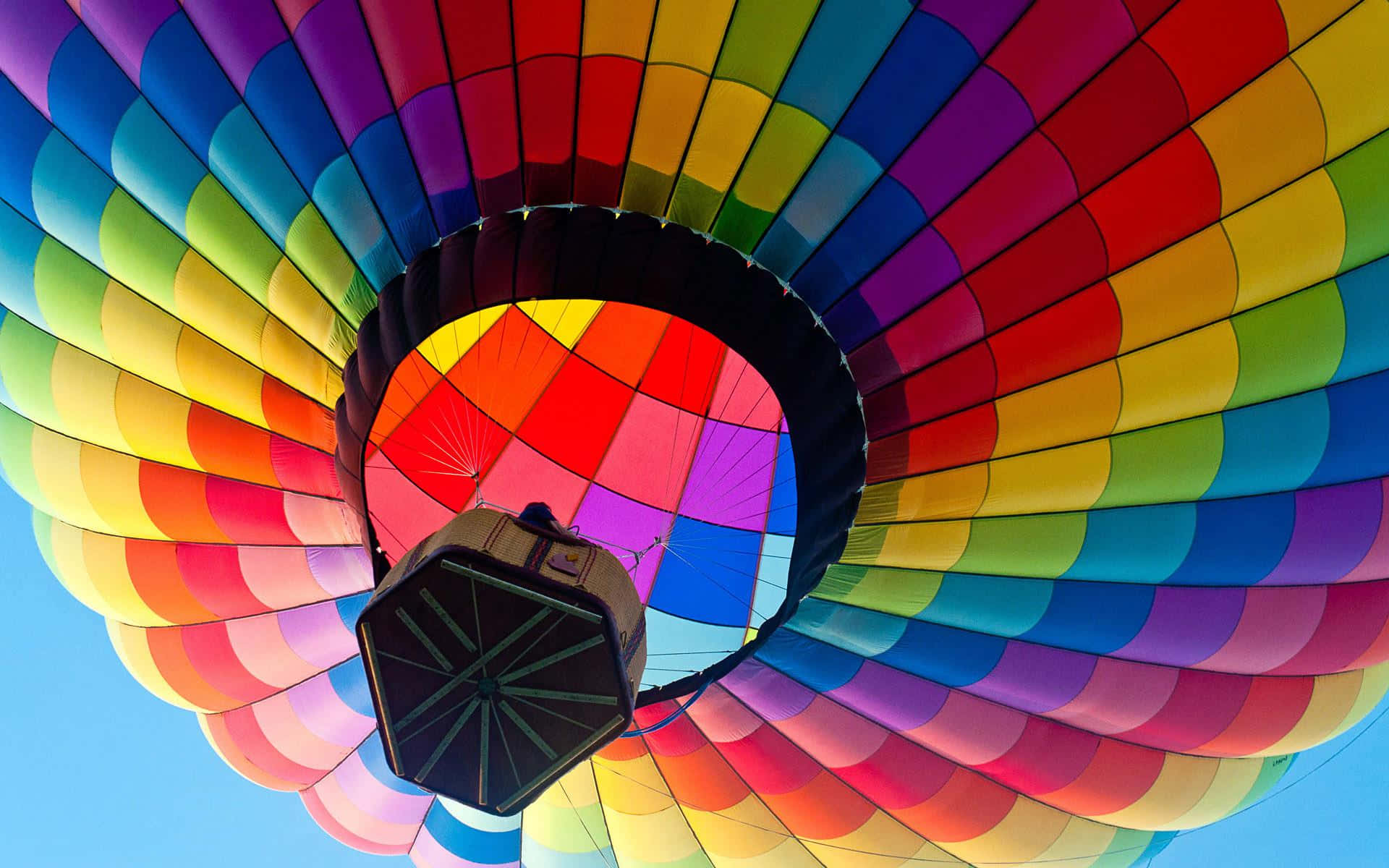 Balloon 桌布 壁紙 — 從下方仰望色彩繽紛的彩虹色熱氣球篷頂，映襯著清澈的藍天。