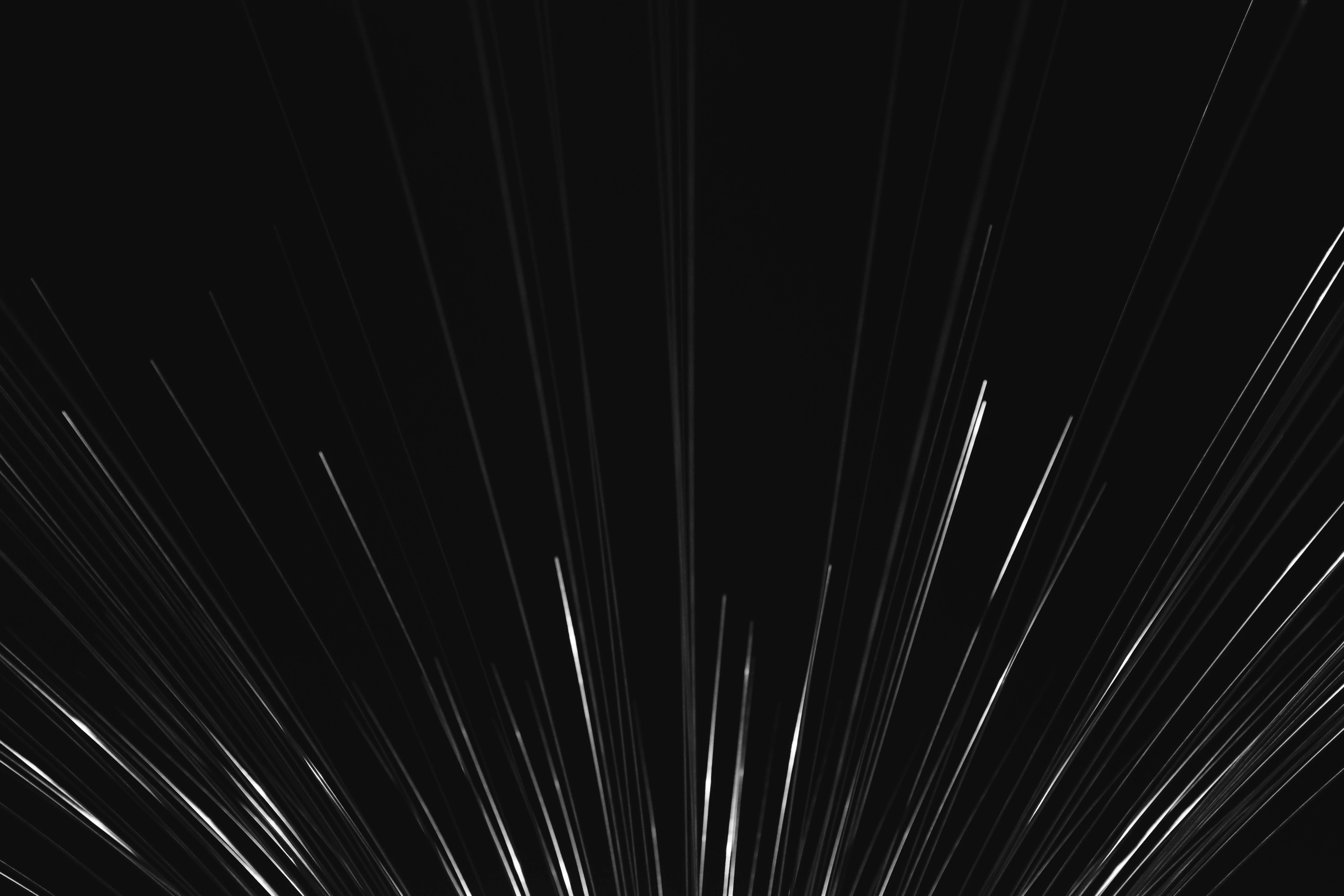 dark black 桌布 壁紙 — 從中心點向外迸發的耀眼白色條紋，在深黑色背景上營造出動態抽象運動效果。