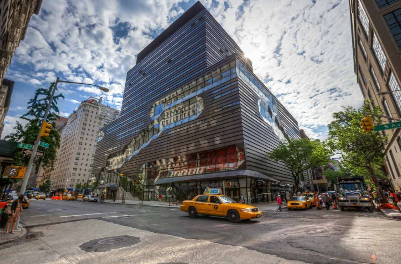 Building 桌布 壁紙 — 從低角度觀看紐約市的現代藝術博物館，黃色計程車和行人在部分多雲的天空下。