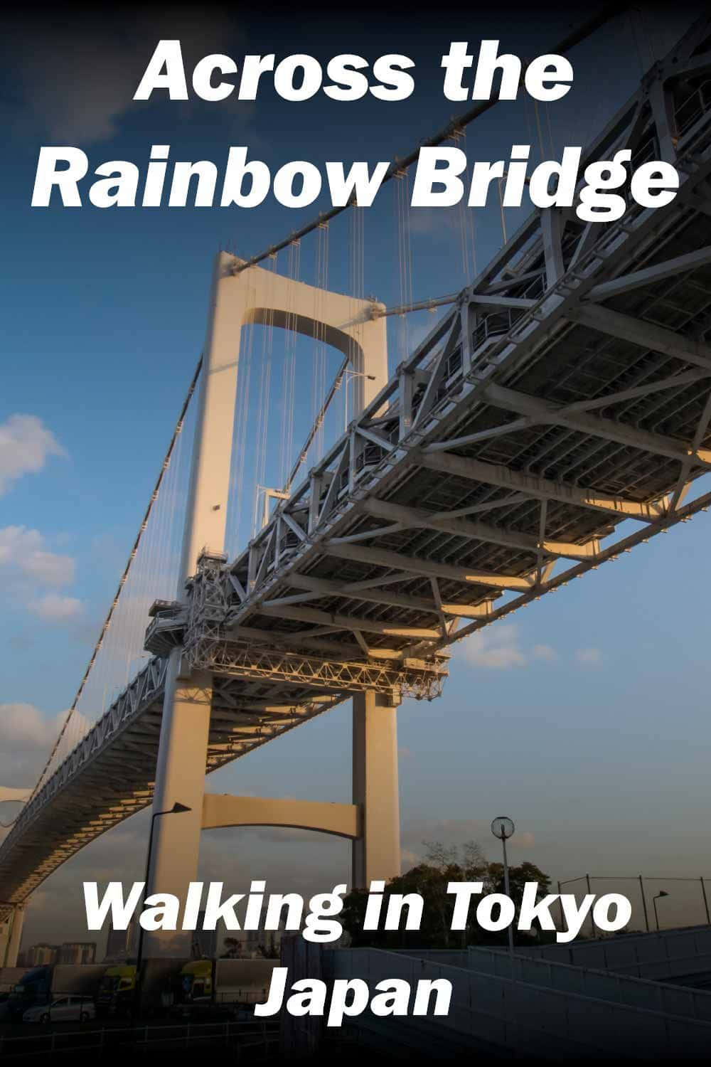 Rainbow Bridge 桌布 壁紙 — 從低角度觀賞日本東京彩虹橋的日落景色，溫暖的光線照射在鋼結構上，映襯著藍天。