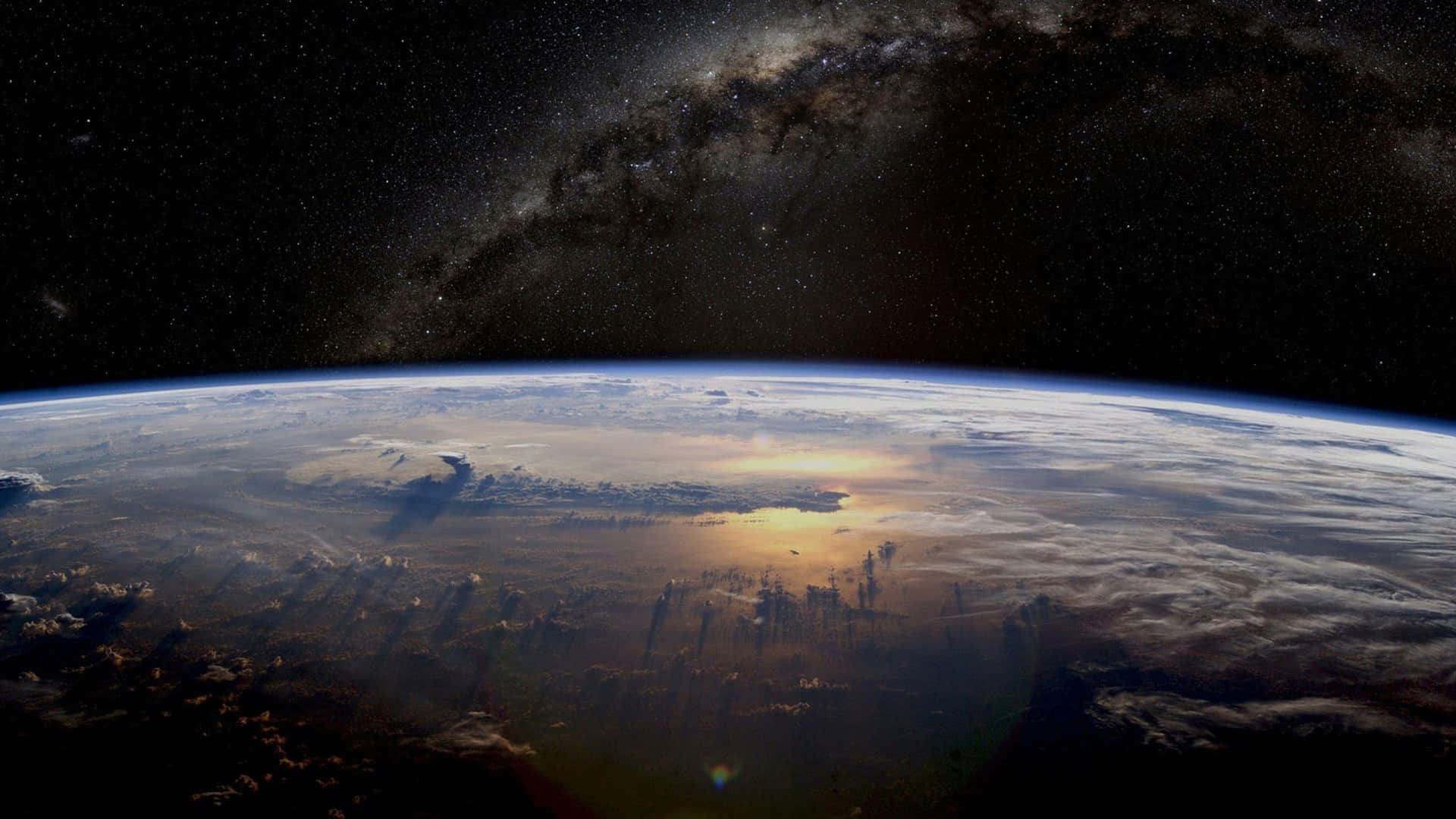 從太空俯瞰地球，背景為銀河系 — 1440P 壁紙