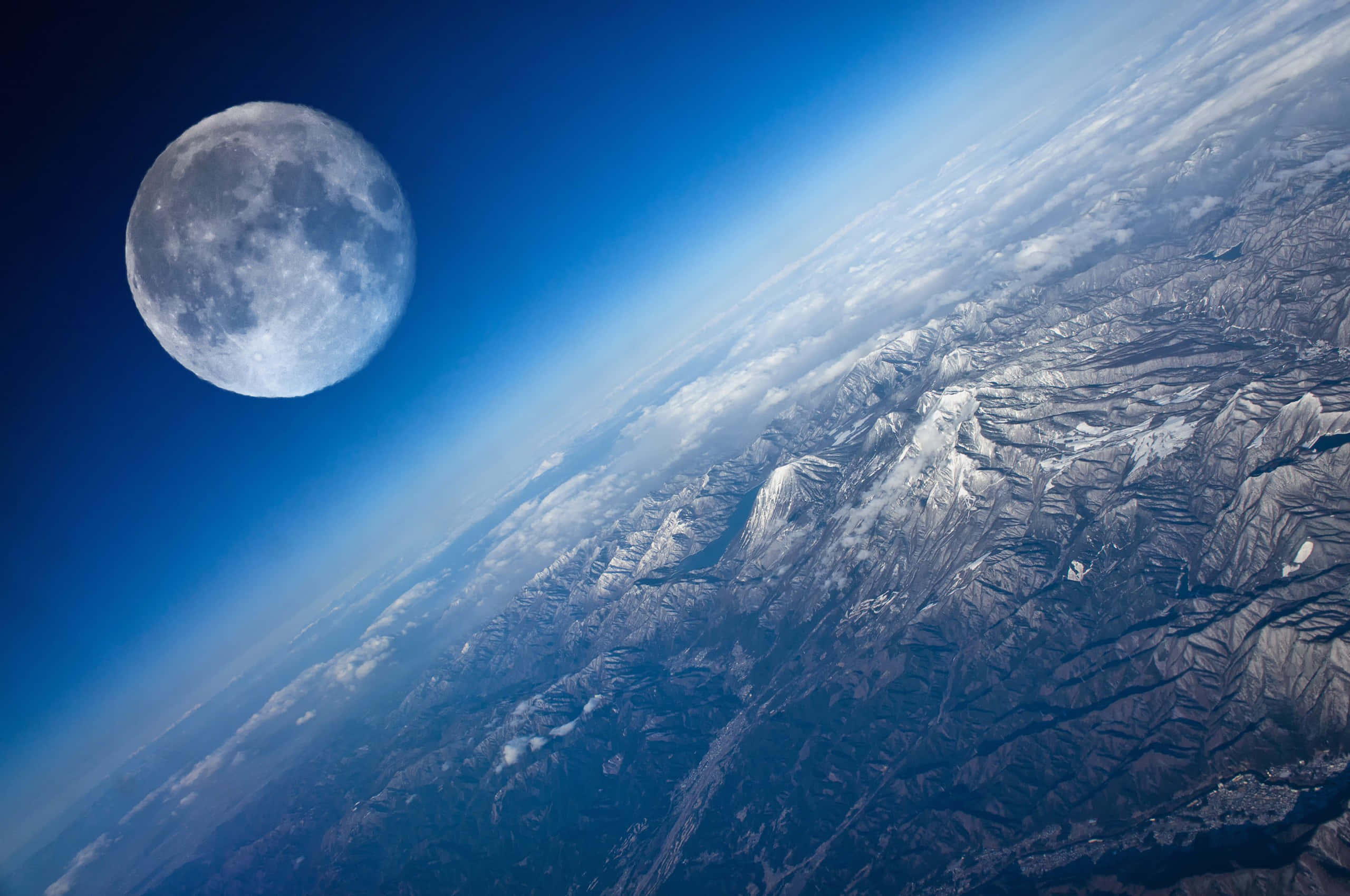 行星動畫 桌布 壁紙 — 從太空俯瞰地球白雪皚皚的山脈，滿月在附近閃耀，令人嘆為觀止。