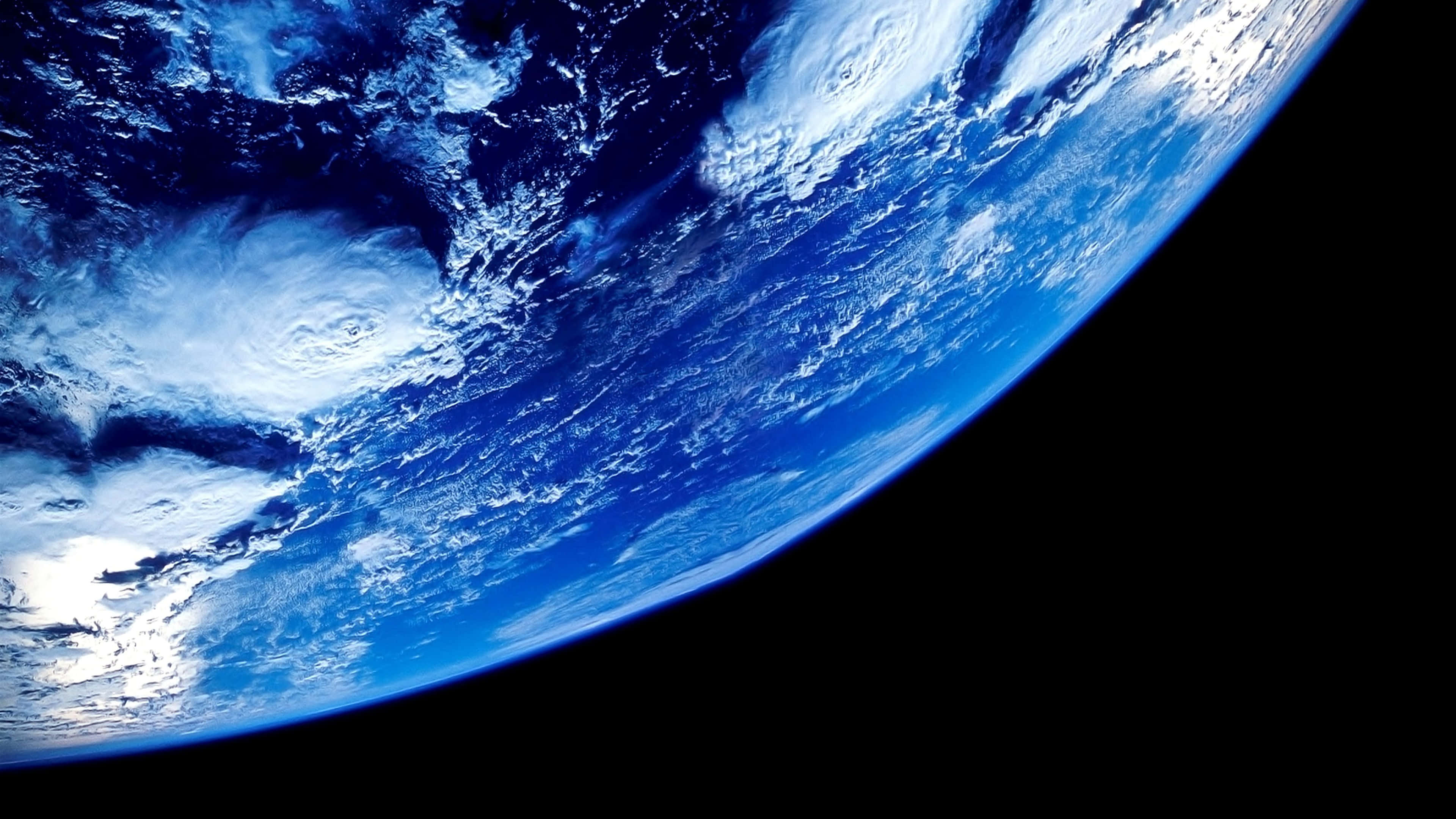 4K Anime Space 桌布 壁紙 — 從太空俯瞰地球的壯觀彎曲景象，展現出蔚藍海洋與白色雲霧在黑色虛空中翻騰。