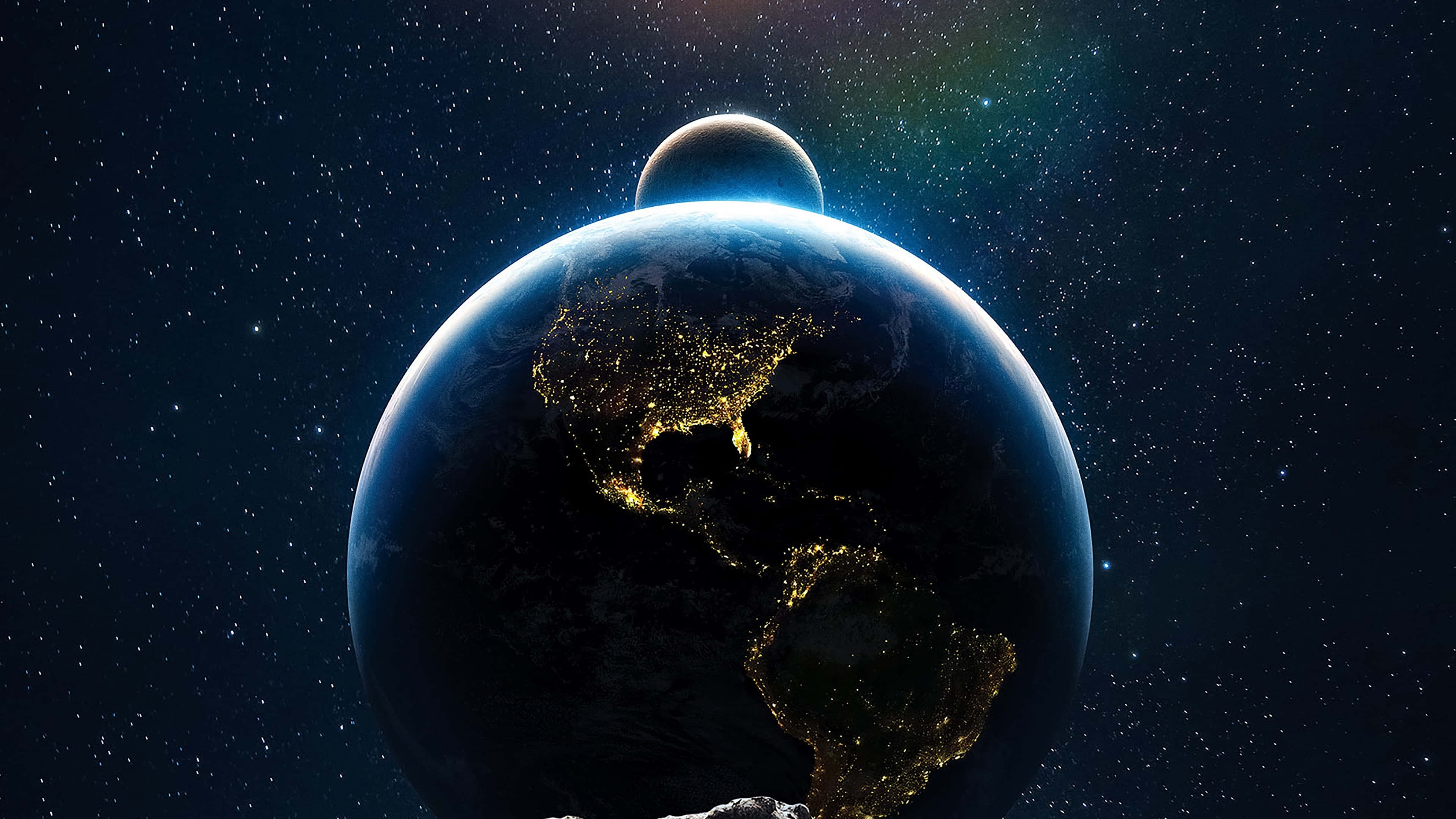 桌布 壁紙 — 從太空俯瞰地球的壯麗景色，北美洲和南美洲上空閃爍的城市燈光，背景中有一輪月亮。