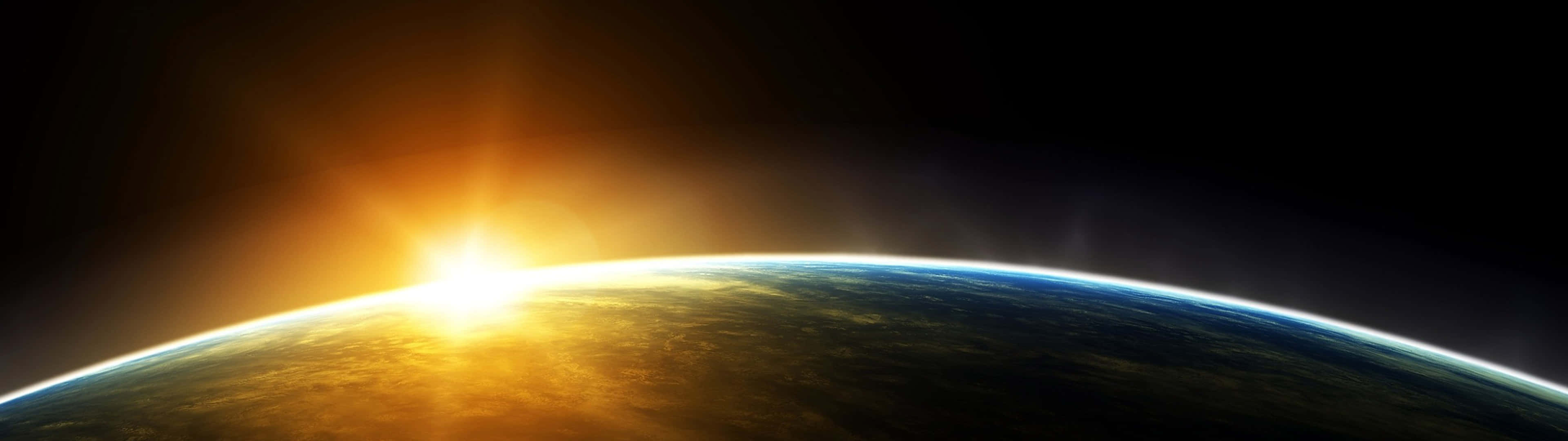 桌布 壁紙 — 從太空俯瞰地球的壯麗景色，太陽從彎曲的地平線升起，將金色光芒灑在雲層和海洋上。