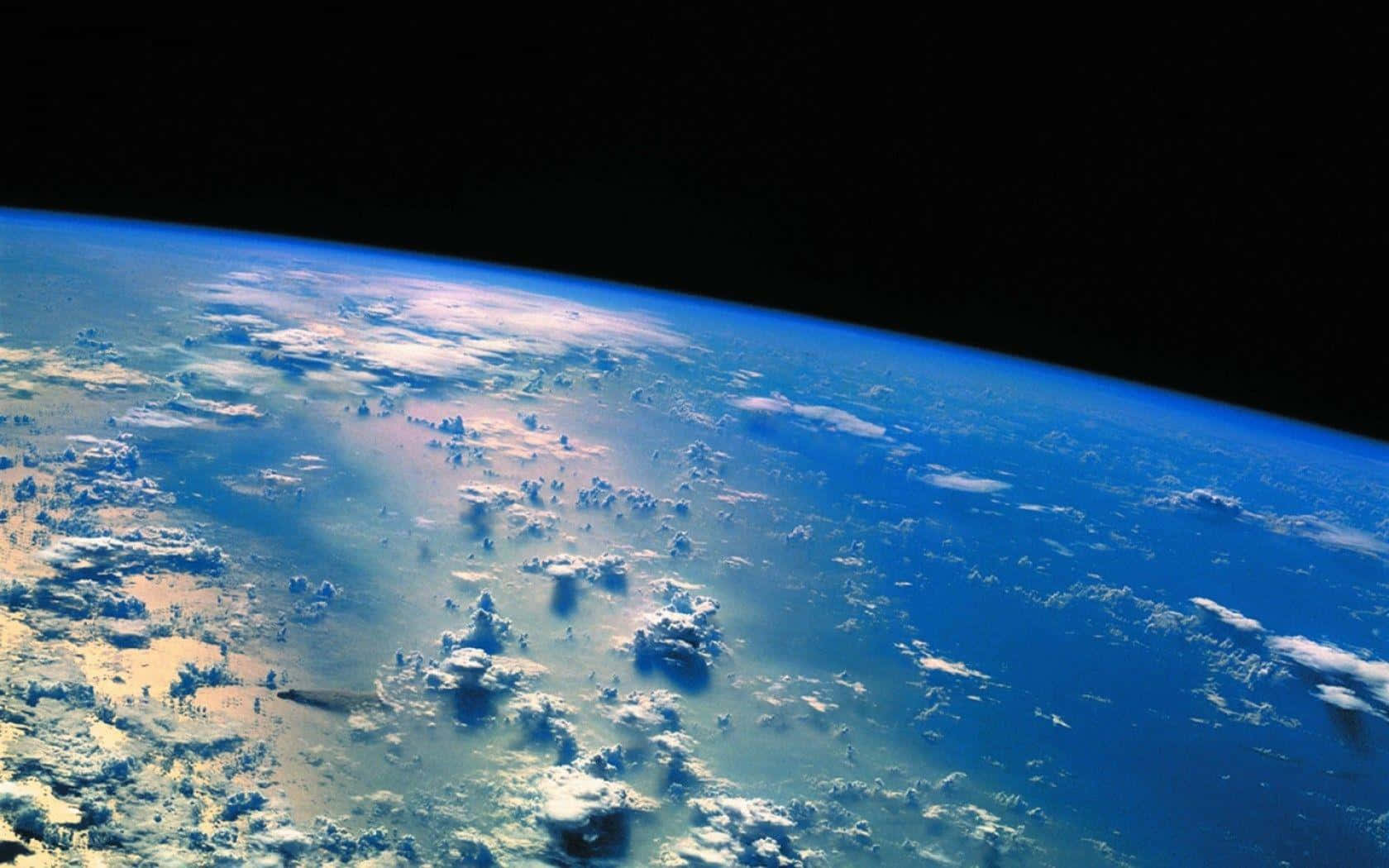桌布 壁紙 — 從太空俯瞰地球的壯麗景色，展現了旋轉的藍色海洋、白色雲層以及黑色太空虛空中的彎曲地平線。